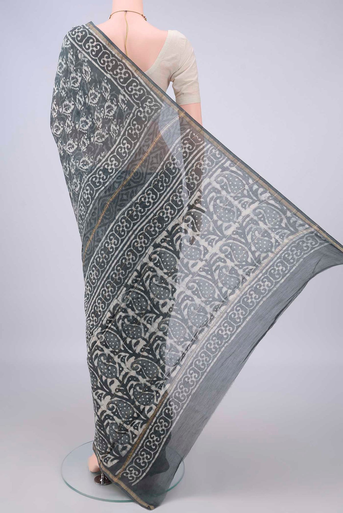 Flat view of Grey Chanderi Cotton Saree with Batik Print on the body and Thin Zari Line. 