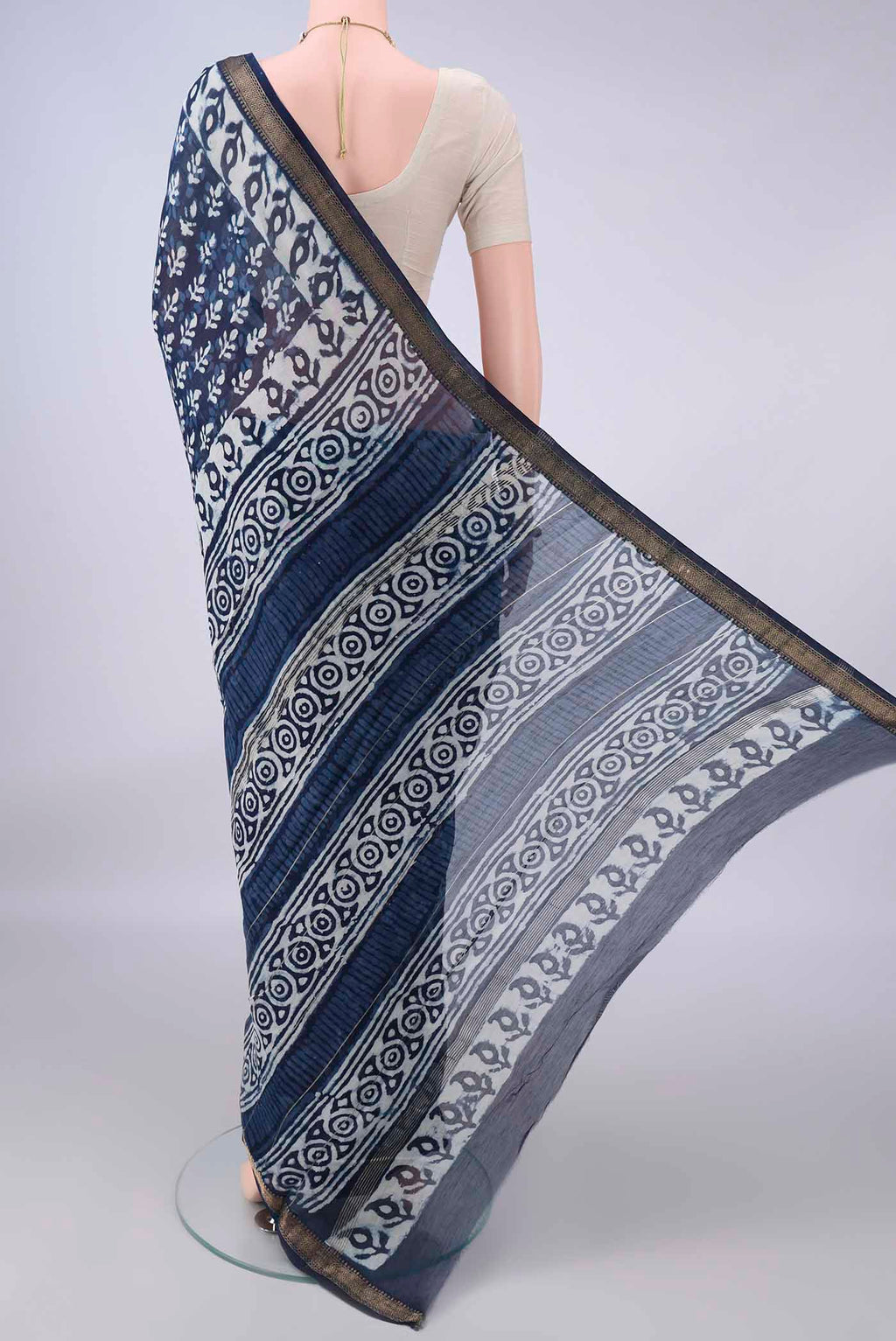 Flat view of Indigo Maheshwari Cotton Saree with Batik Print on the body and Zari Border. 