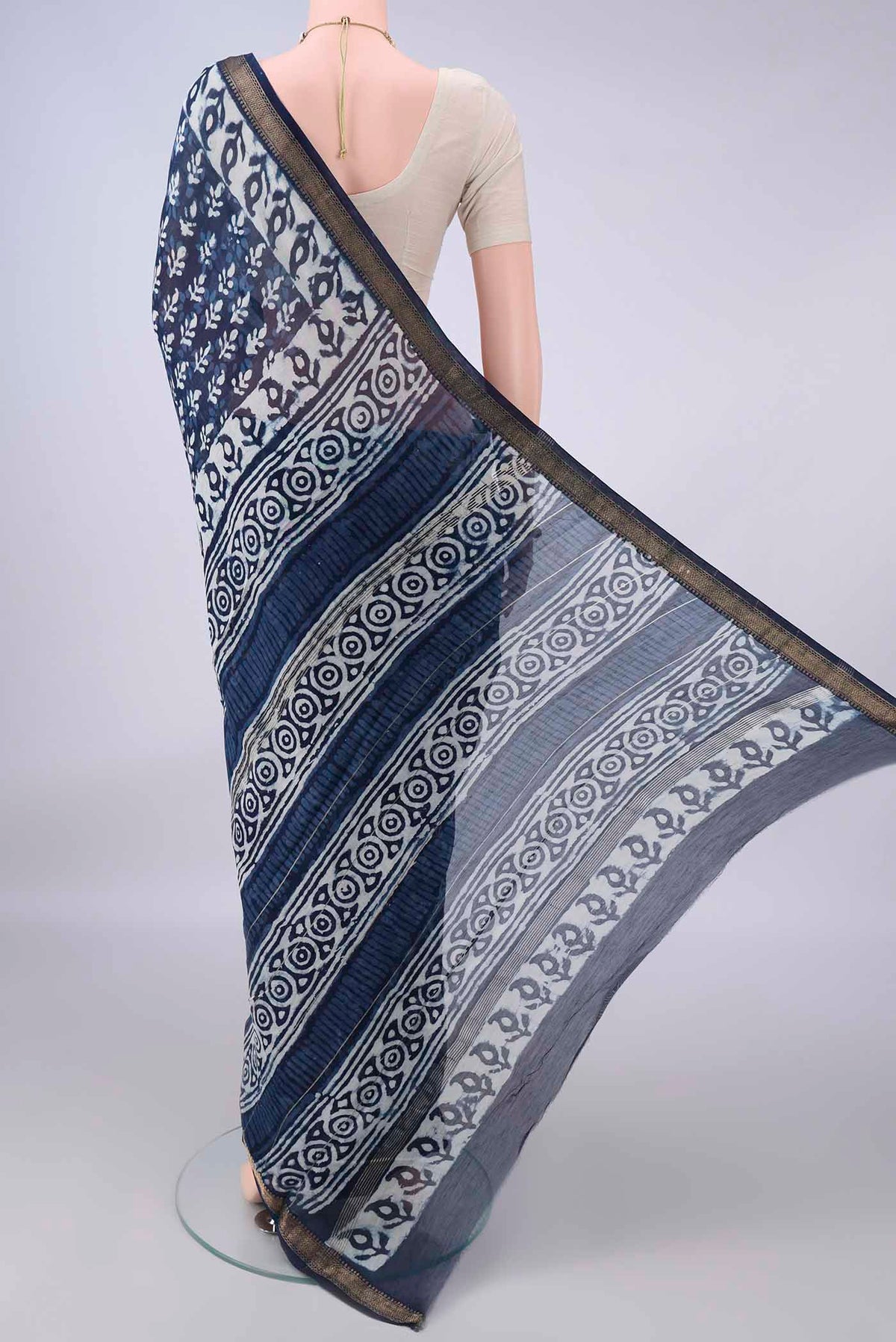 Flat view of Indigo Maheshwari Cotton Saree with Batik Print on the body and Zari Border. 