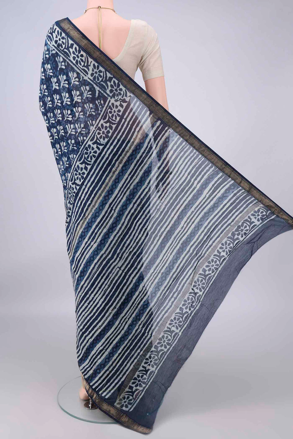 Flat view of Indigo Maheshwari Cotton Saree with Batik Print on the body and Zari Border. 