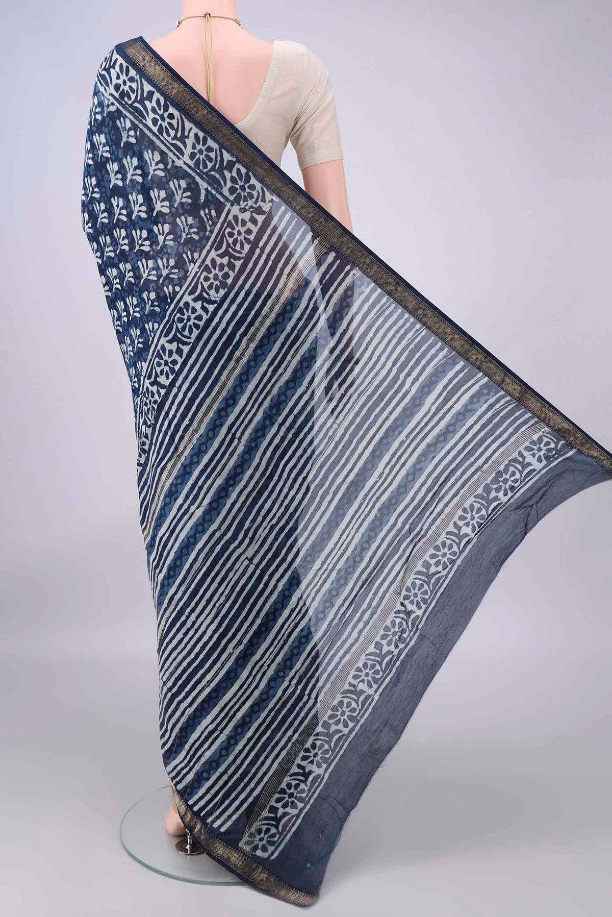 Flat view of Indigo Maheshwari Cotton Saree with Batik Print on the body and Zari Border. 