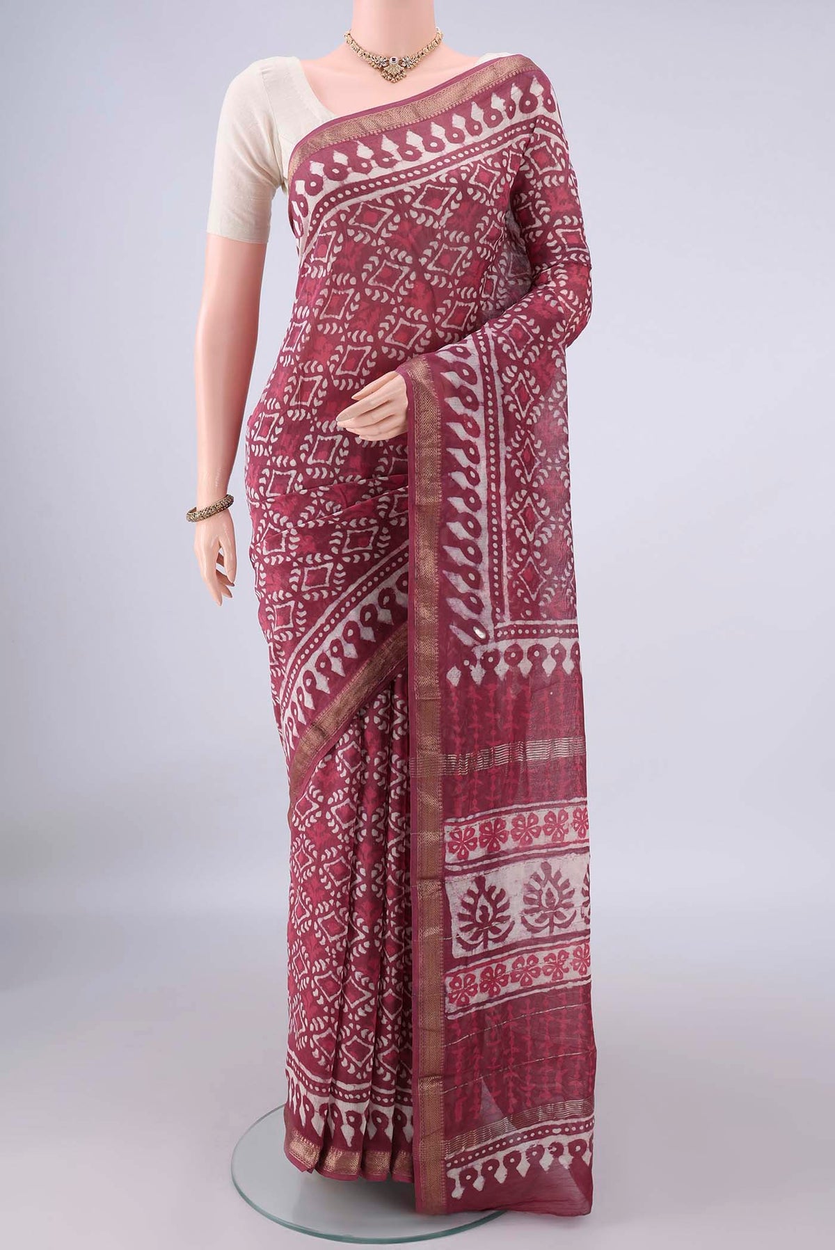 Coral Maheshwari Cotton Saree with Batik Print on the body and Zari Border.  displayed on a mannequin