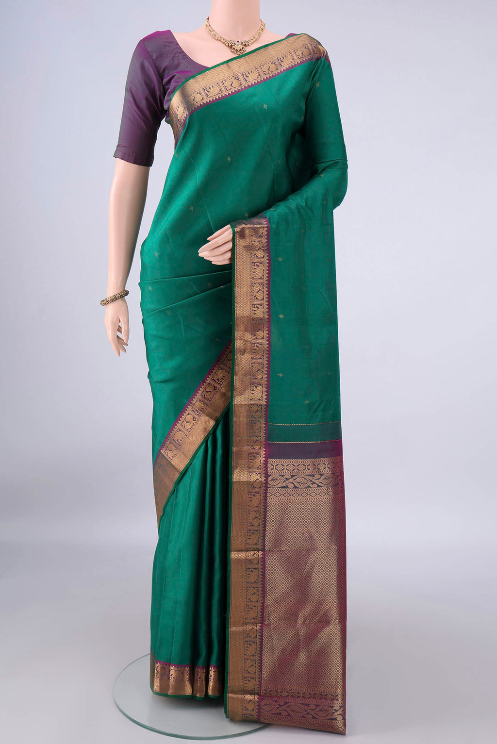Pure Silk Green Kanchipuram Saree with Zari Butta on the body and Zari Border.  displayed on a mannequin