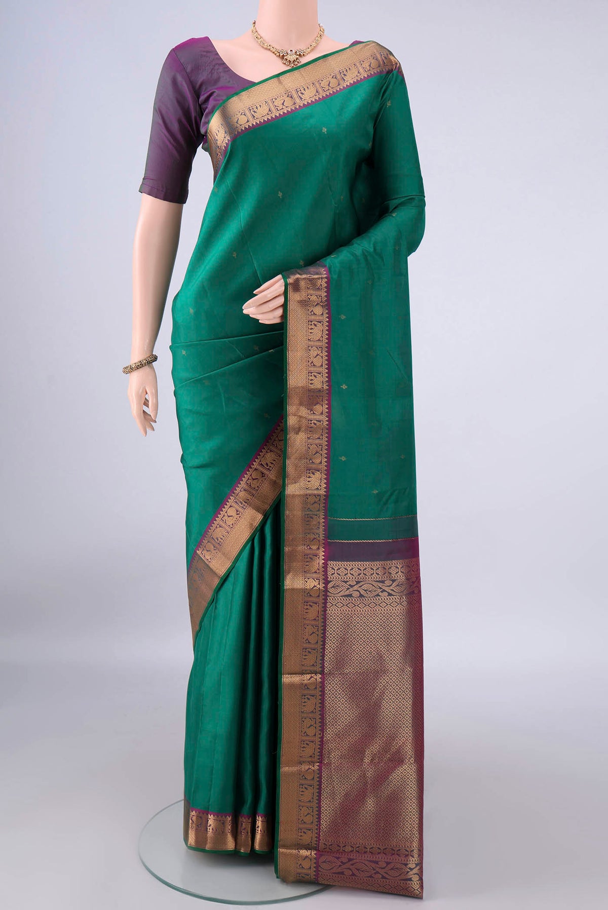 Pure Silk Green Kanchipuram Saree with Zari Butta on the body and Zari Border.  displayed on a mannequin