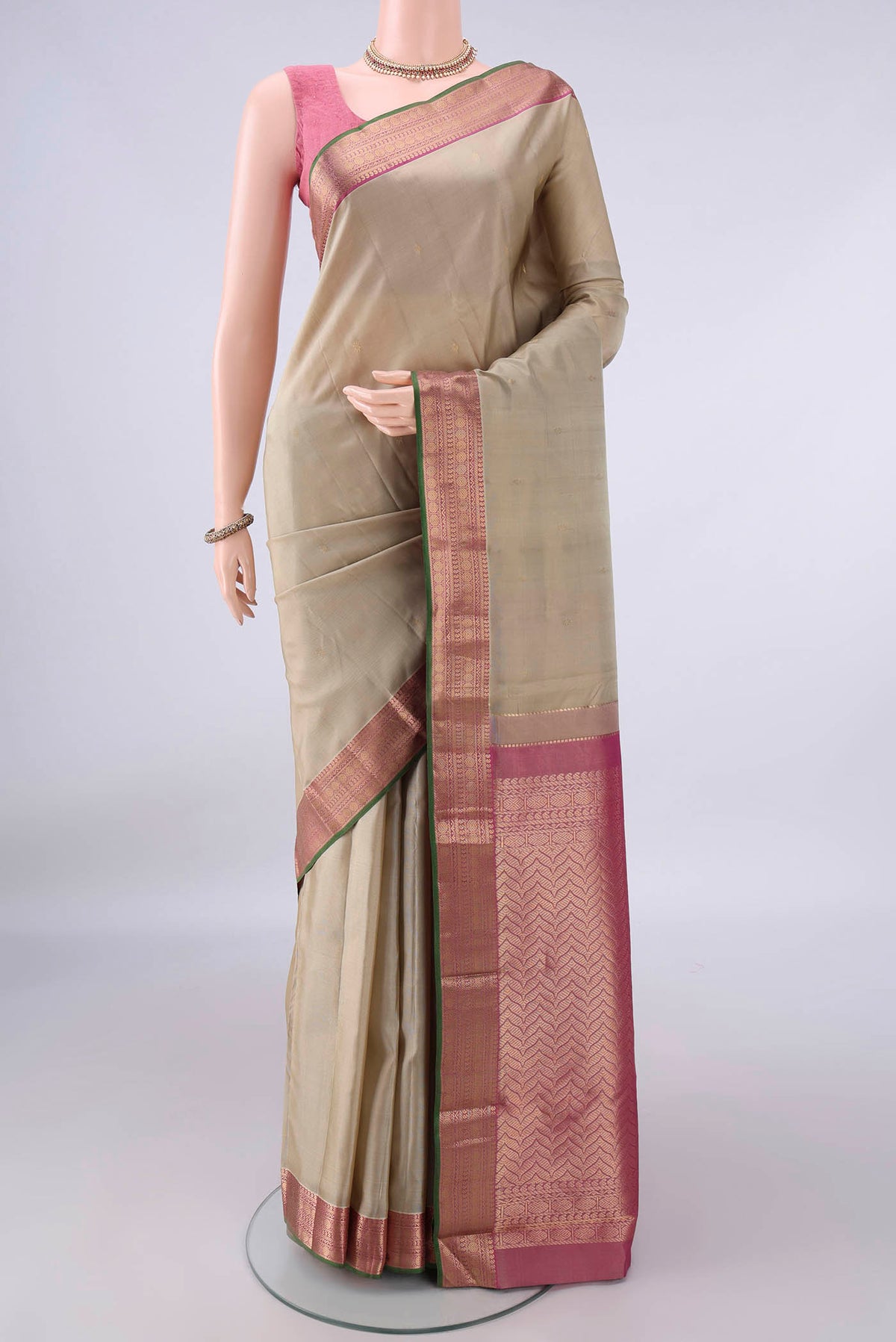 Pure Silk Dark Beige Kanchipuram Saree with Zari Butta on the body and Zari Border.  displayed on a mannequin
