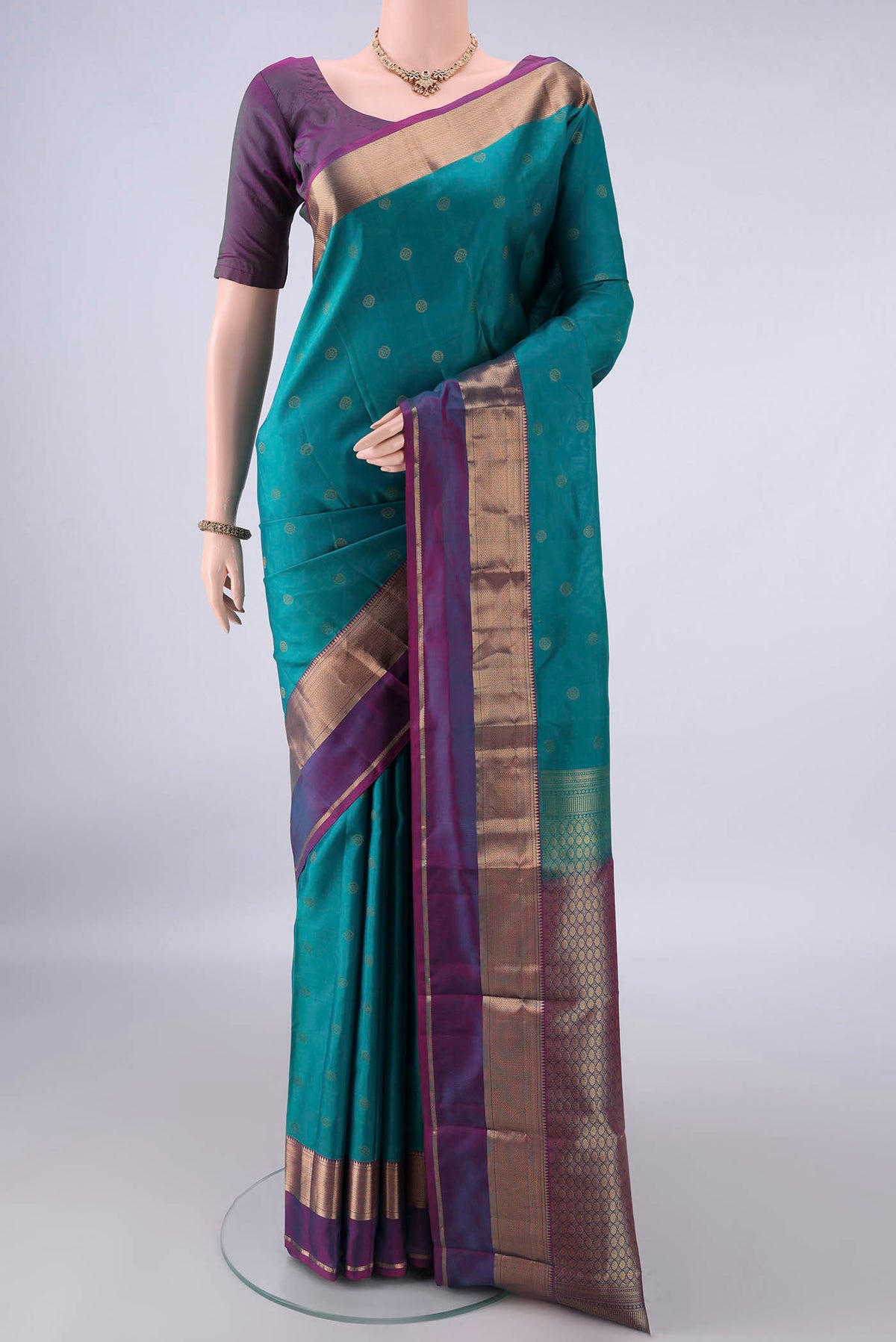 Pure Silk Green Kanchipuram Saree with Zari Butta on the body and Zari Border.  displayed on a mannequin