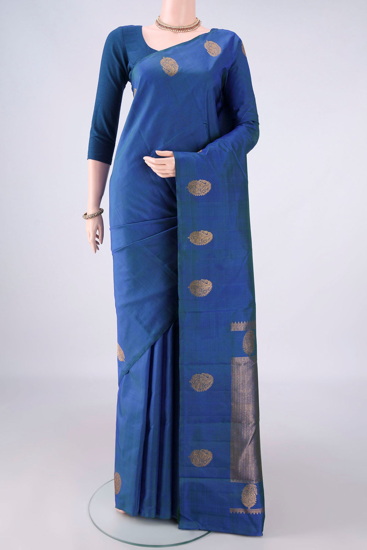 Pure Silk Peacock Blue Dual Tone Kanjivaram Saree with Plain Body and Without Border.  displayed on a mannequin
