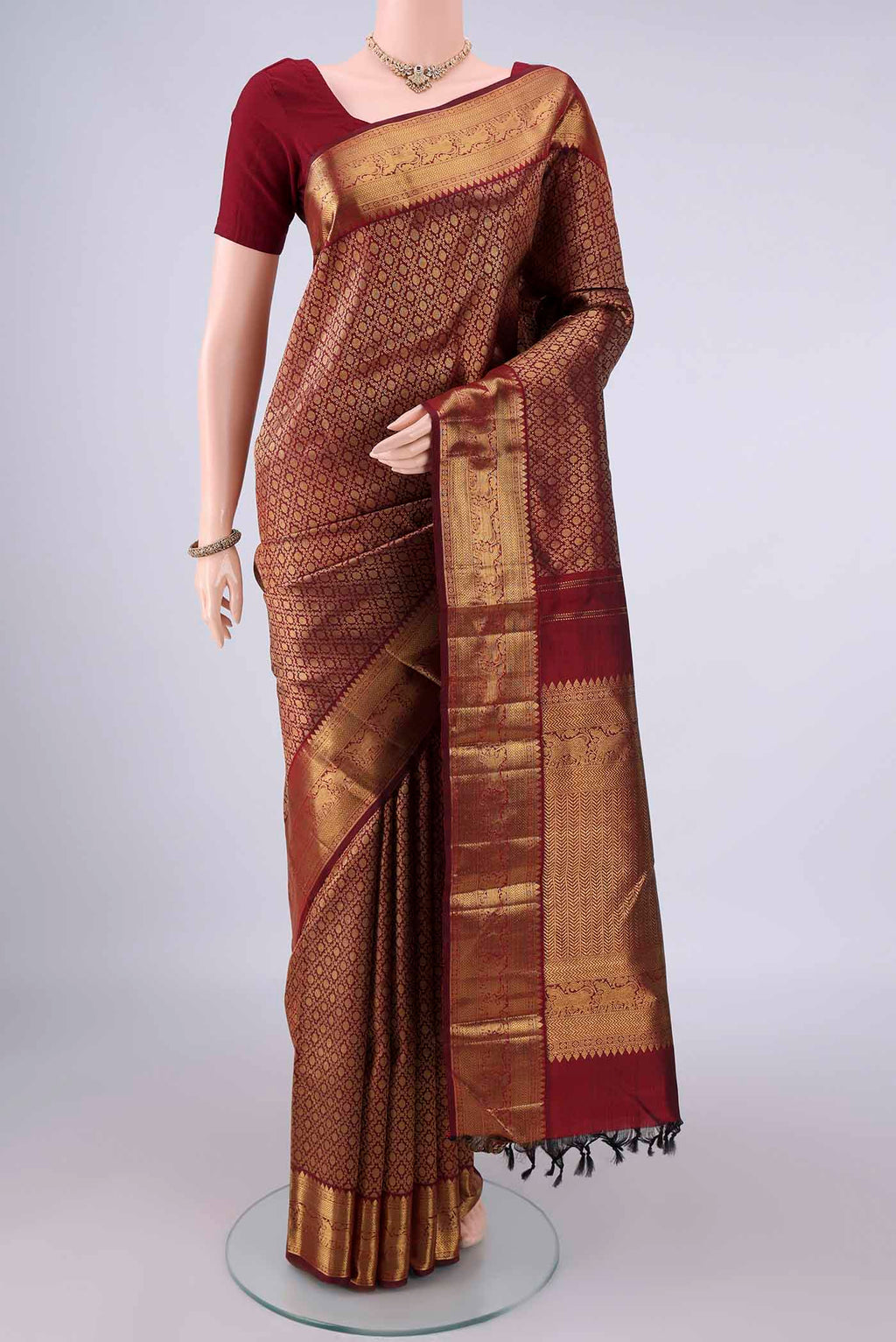 Pure Silk Maroon Kanchipuram Saree with Zari Brocade on the body and Zari Border.  displayed on a mannequin
