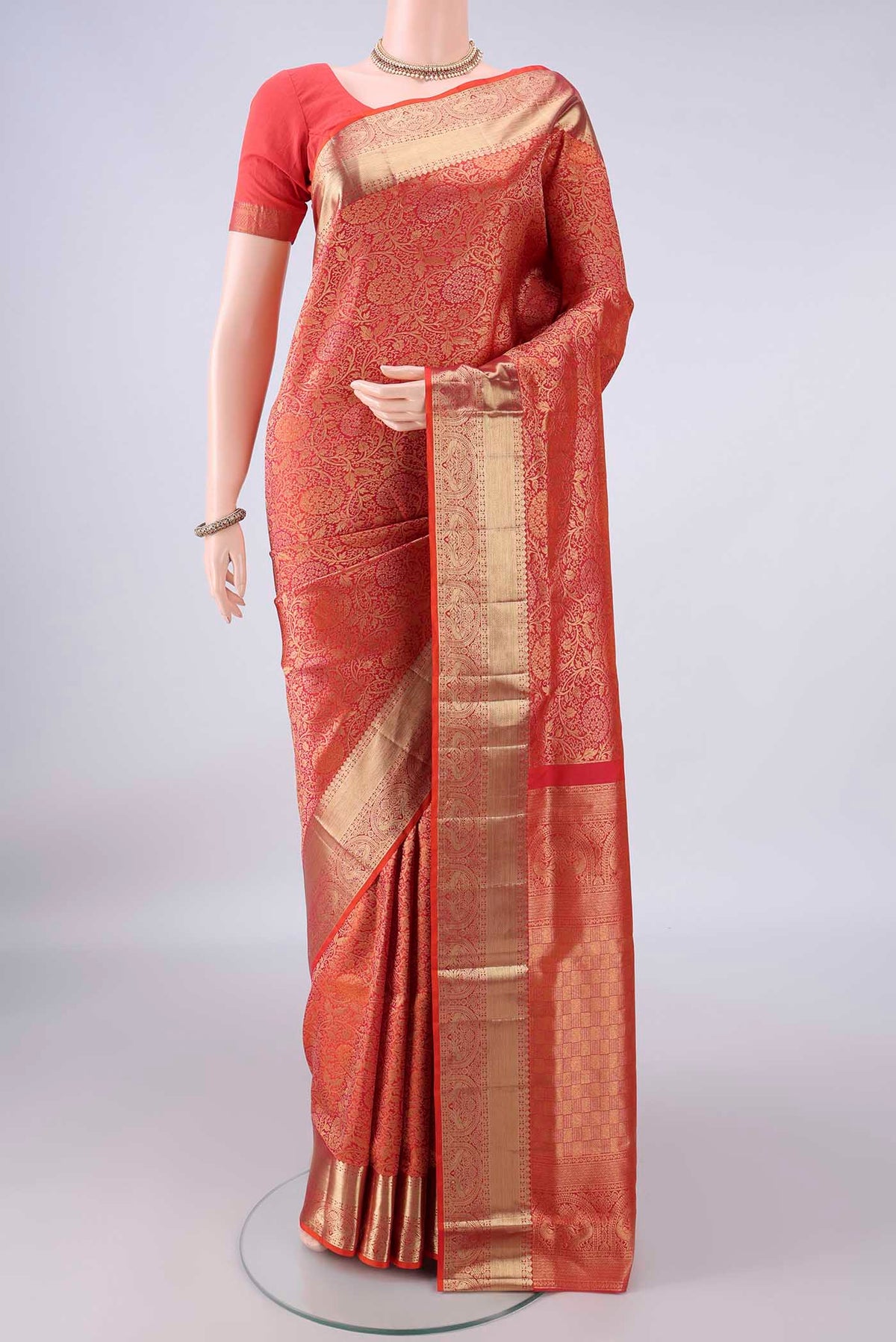 Pure Silk Brick Orange Soft Saree with Zari Brocade on the body and Zari Border.  displayed on a mannequin