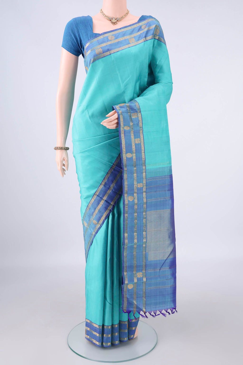 Pure Silk Turquoise Kanchipuram Saree with Plain Body and Zari Border.  displayed on a mannequin