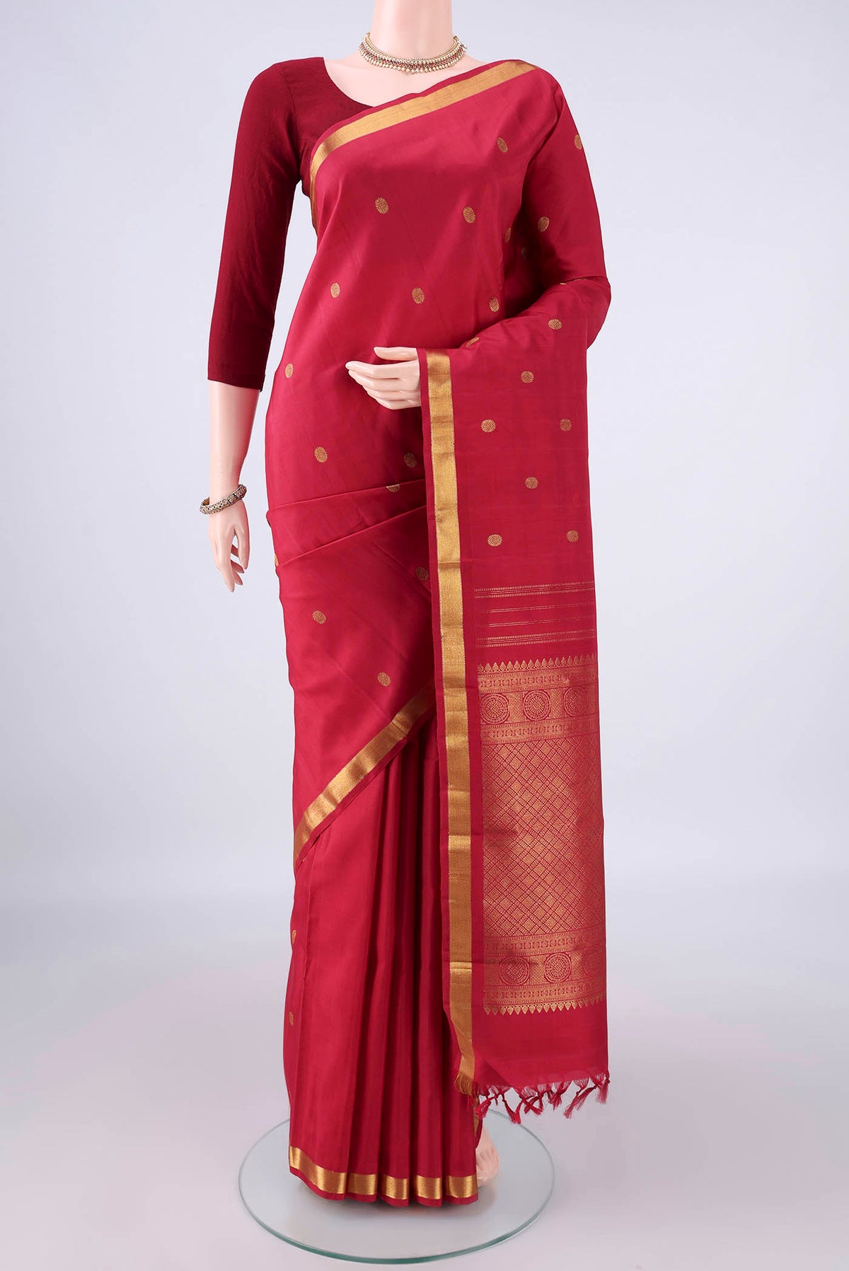 Pure Silk Deep Red Kanjivaram Saree with Zari Butta on the body and Zari Border.  displayed on a mannequin