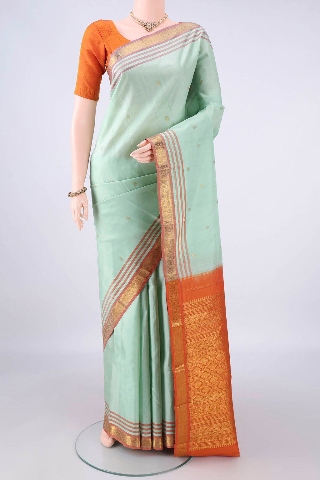 Pure Silk Pista Green Kanjivaram Saree with Zari Butta on the body and Zari Border.  displayed on a mannequin
