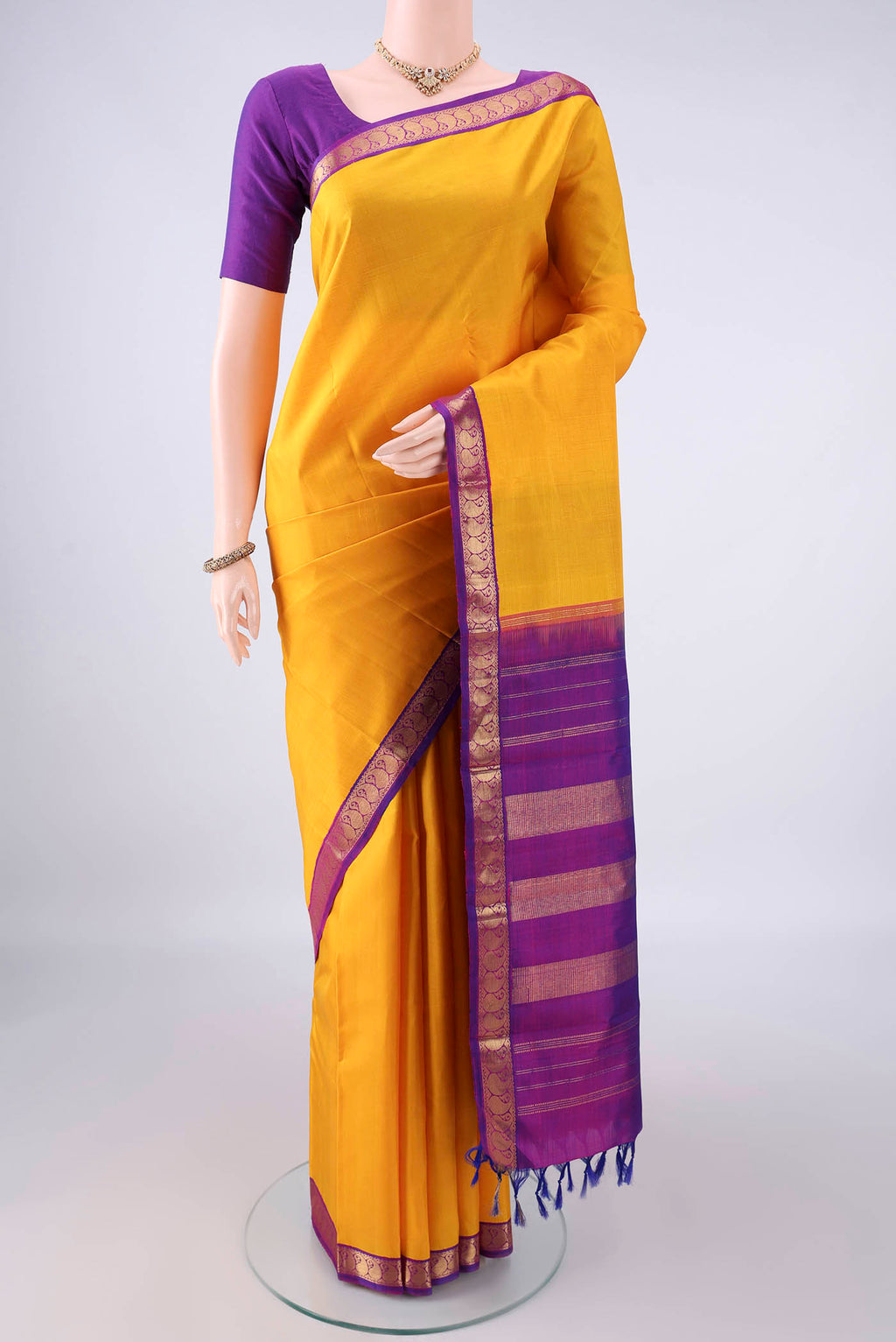 Pure Silk Yellow Kanjivaram Saree with Plain Body and Zari Border.  displayed on a mannequin