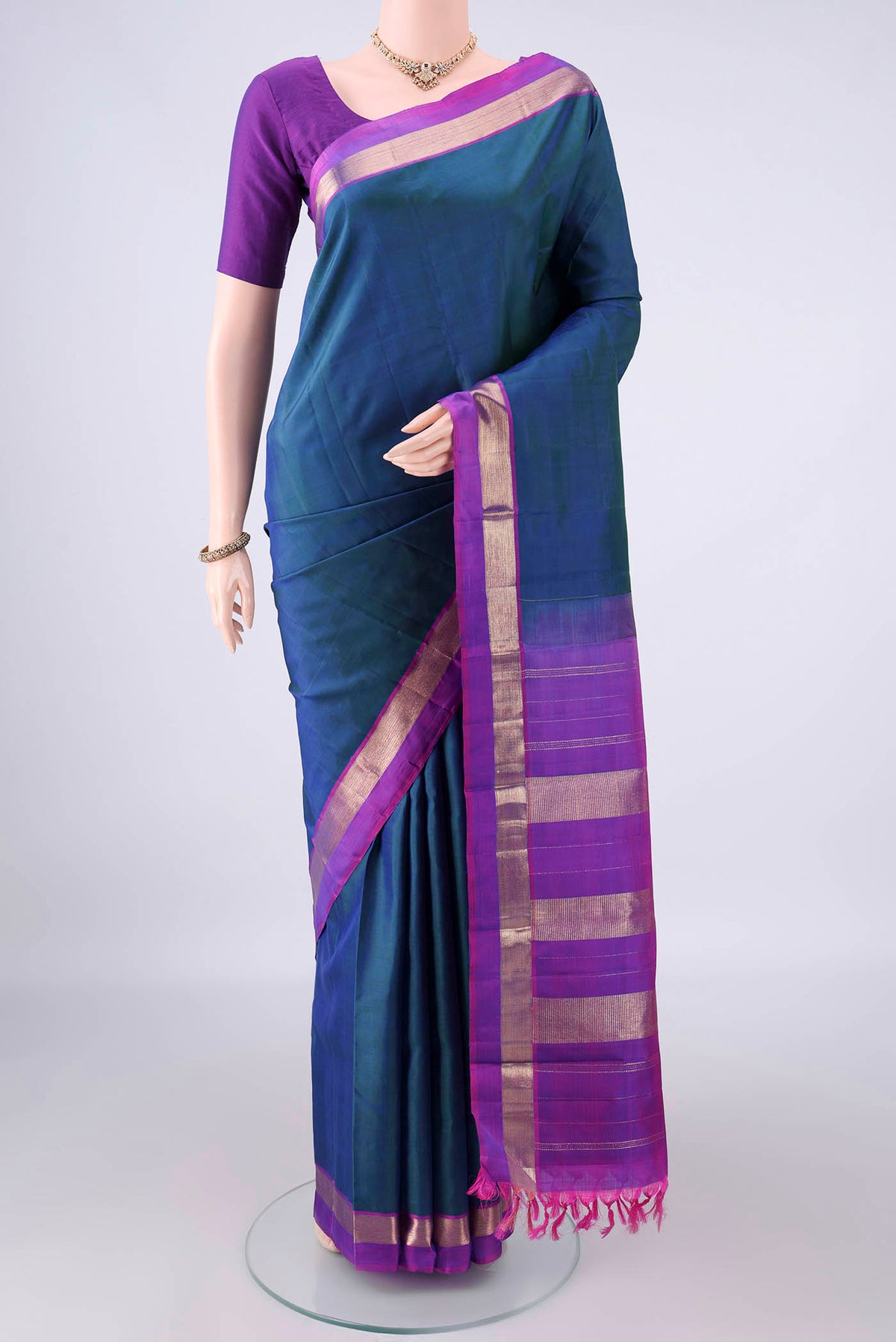 Pure Silk Peacock Blue Dual Tone Kanjivaram Saree with Plain Body and Zari Border.  displayed on a mannequin