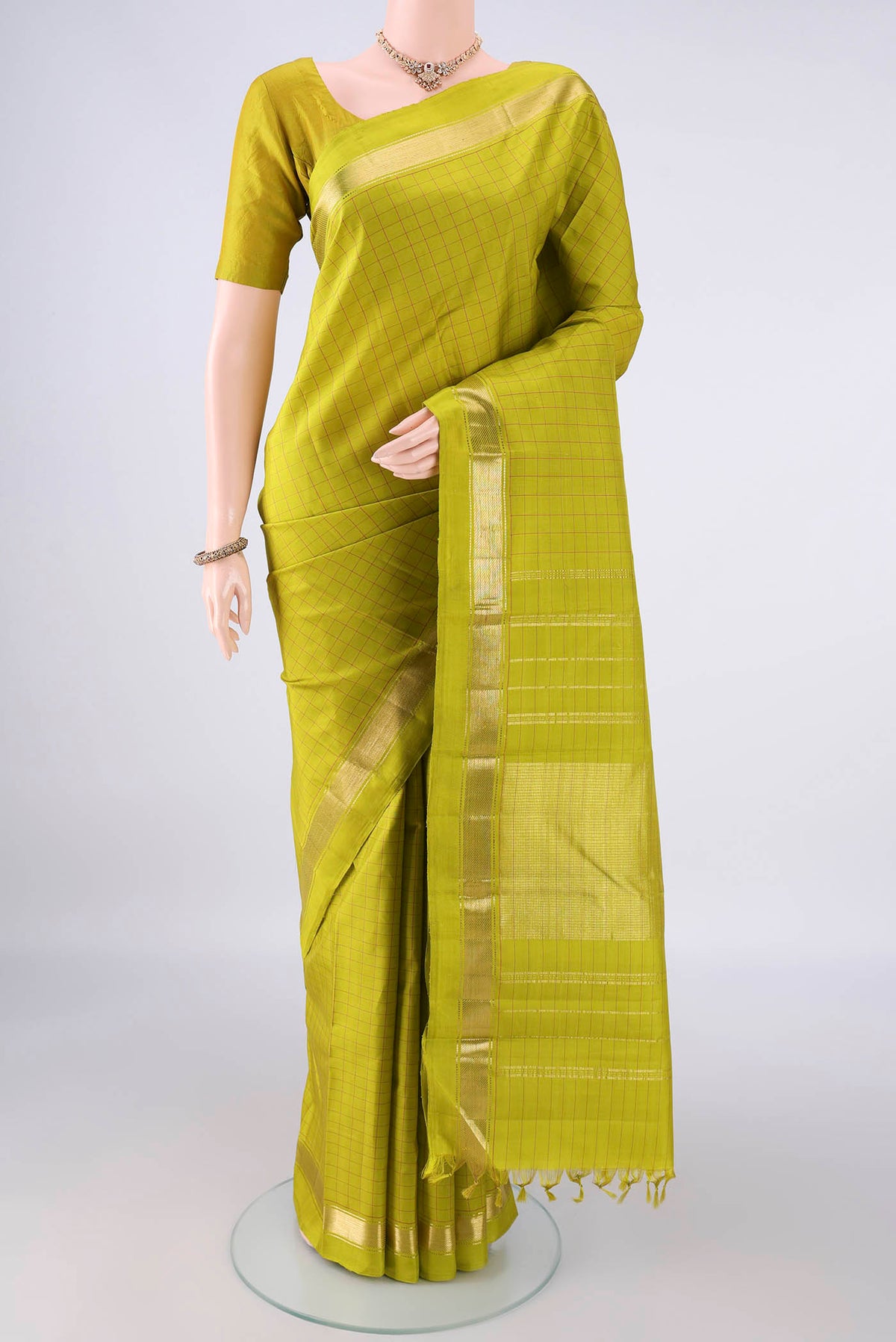 Pure Silk Parrot Green Kanchipuram Saree with Checked design on the body and Zari Border.  displayed on a mannequin