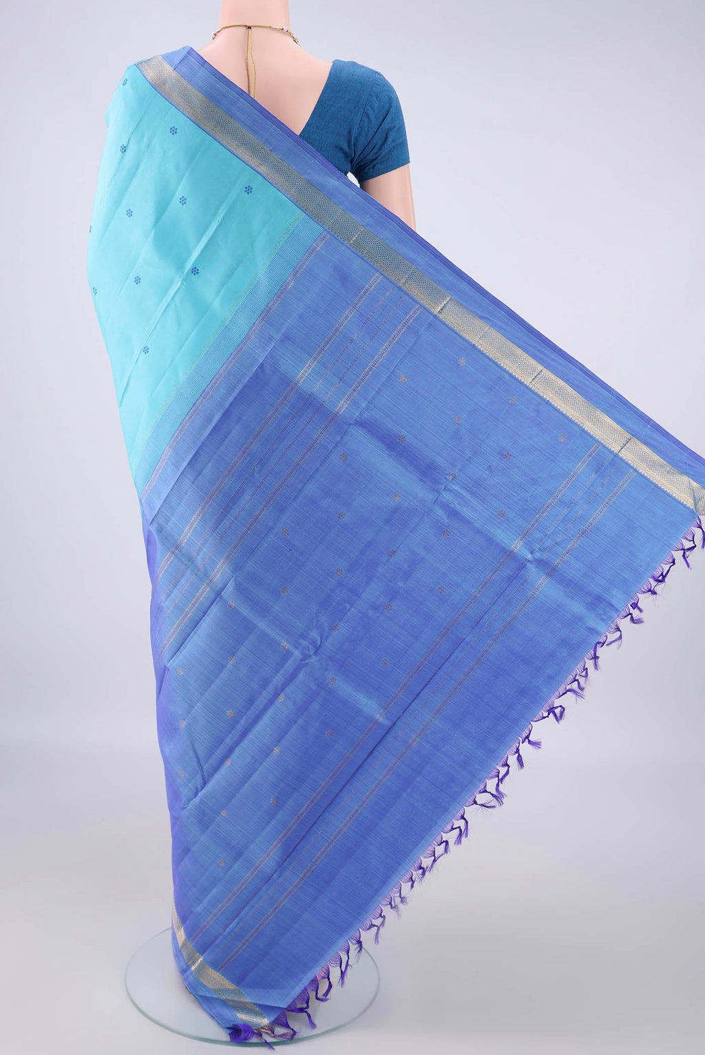 Flat view of Pure Silk Sky Blue Kanchipuram Saree with Thread Butta on the body and Zari Border. 