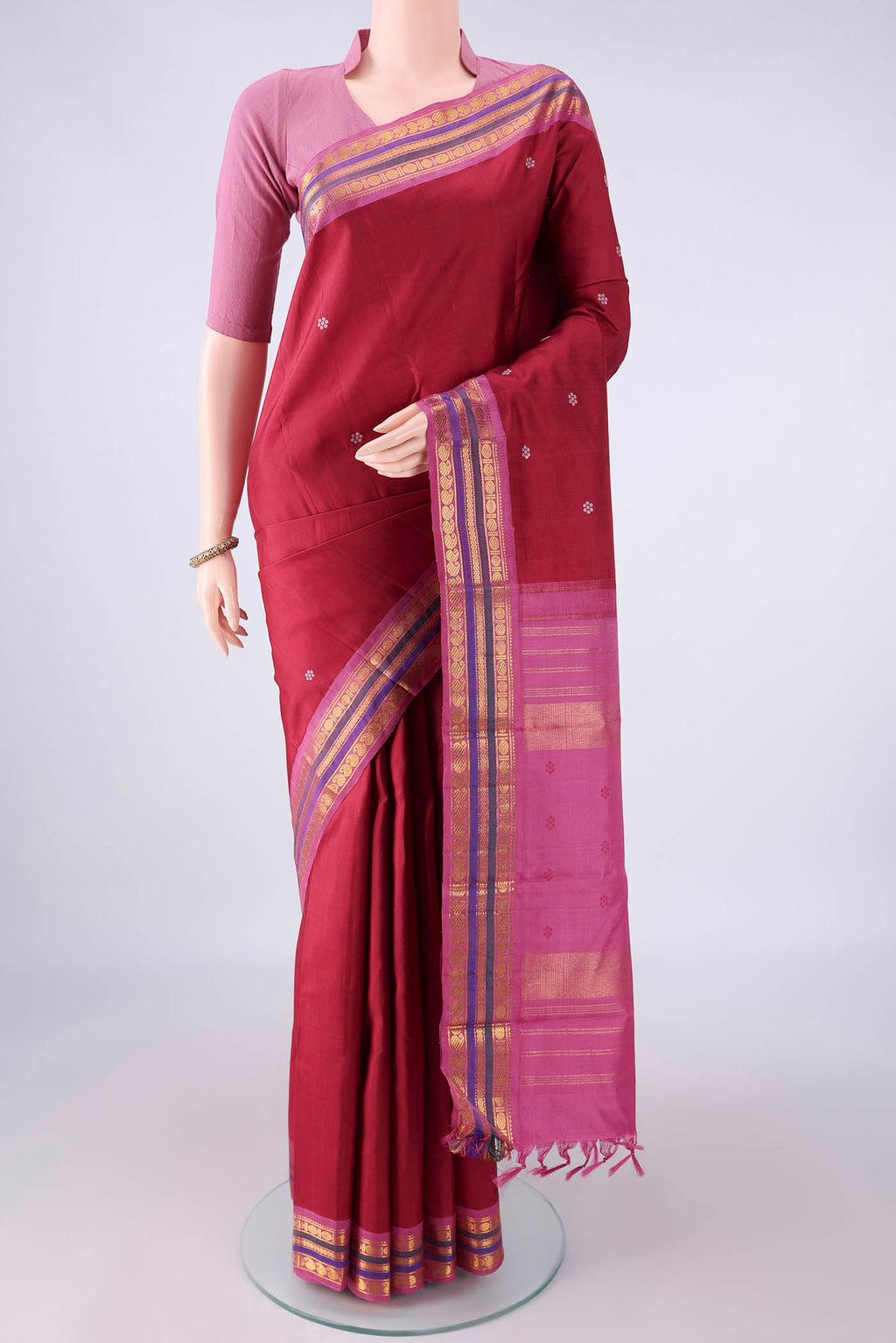 Pure Silk Maroon Kanjivaram Saree with Thread Butta on the body and Zari Border.  displayed on a mannequin