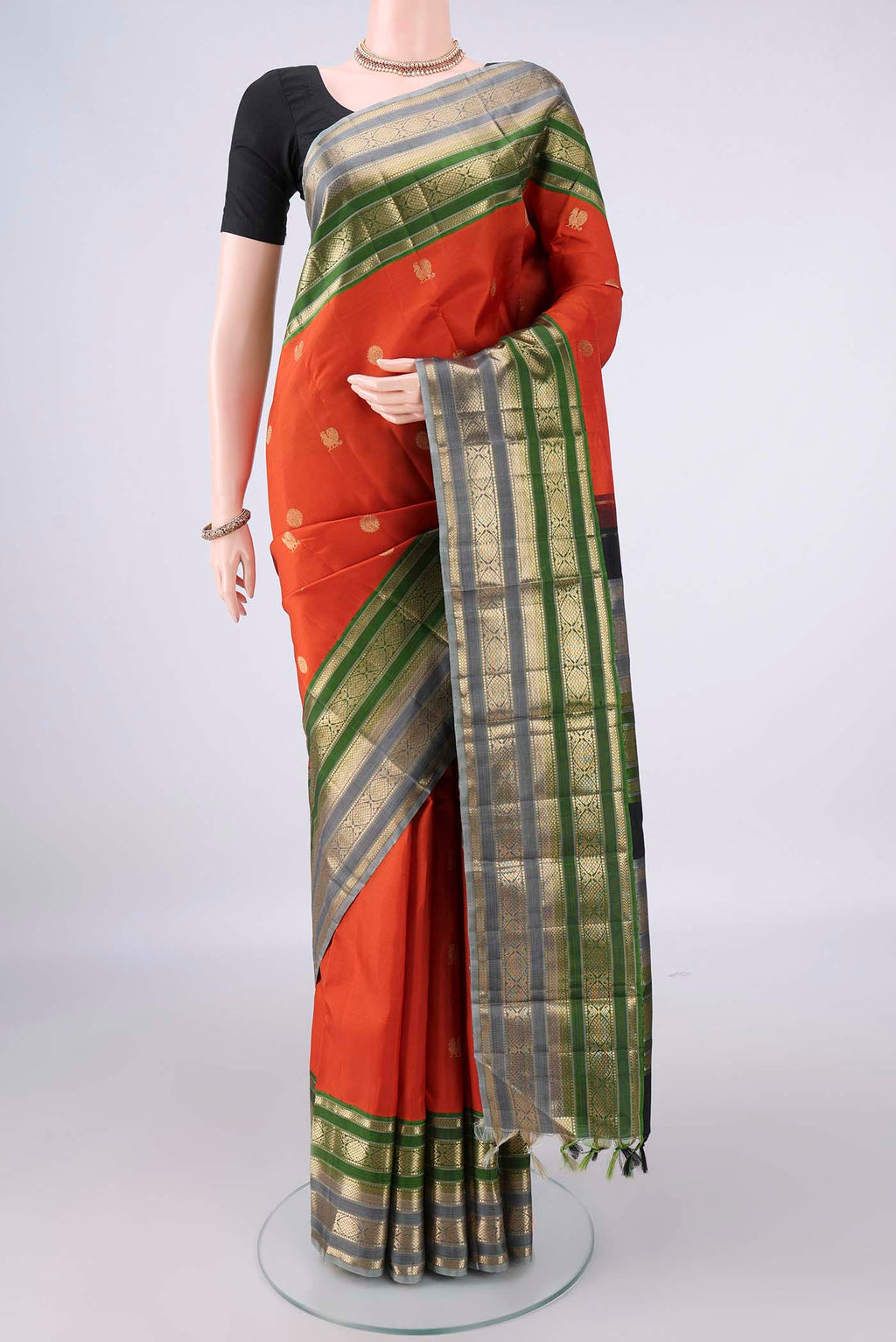 Pure Silk Orange Kanchipuram Saree with Zari Butta on the body and Zari Border.  displayed on a mannequin