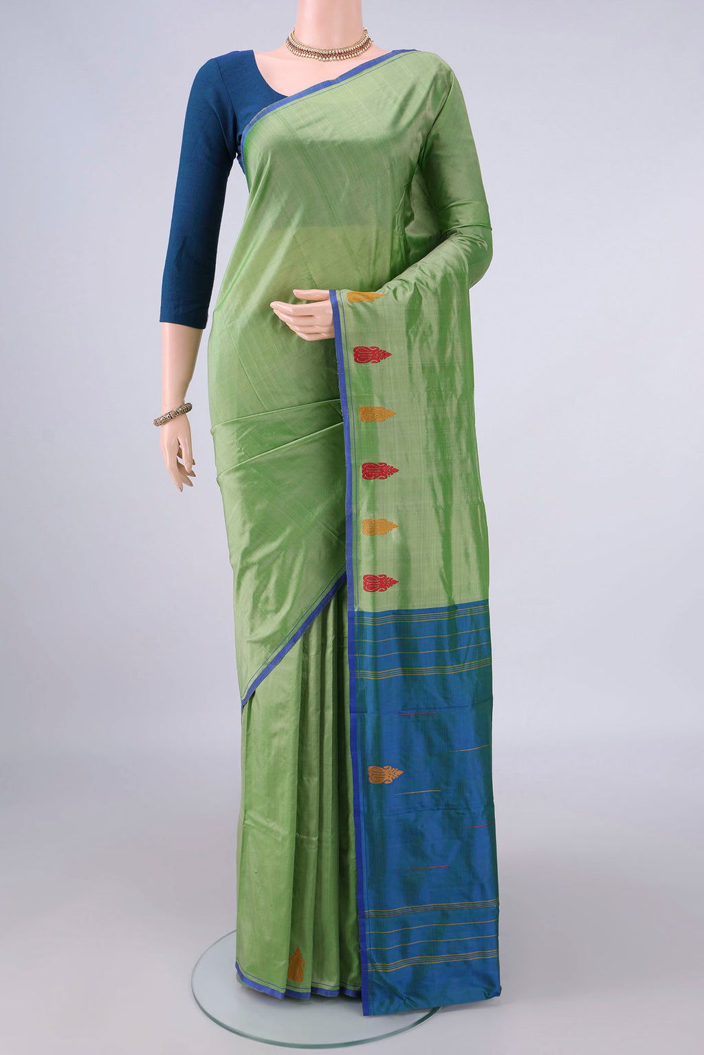 Pure Silk Light Green Kanchipuram Saree with Plain Body and Thread Border.  displayed on a mannequin
