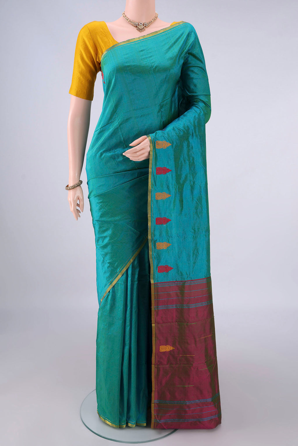 Pure Silk Sea Green Kanchipuram Saree with Plain Body and Zari Border.  displayed on a mannequin
