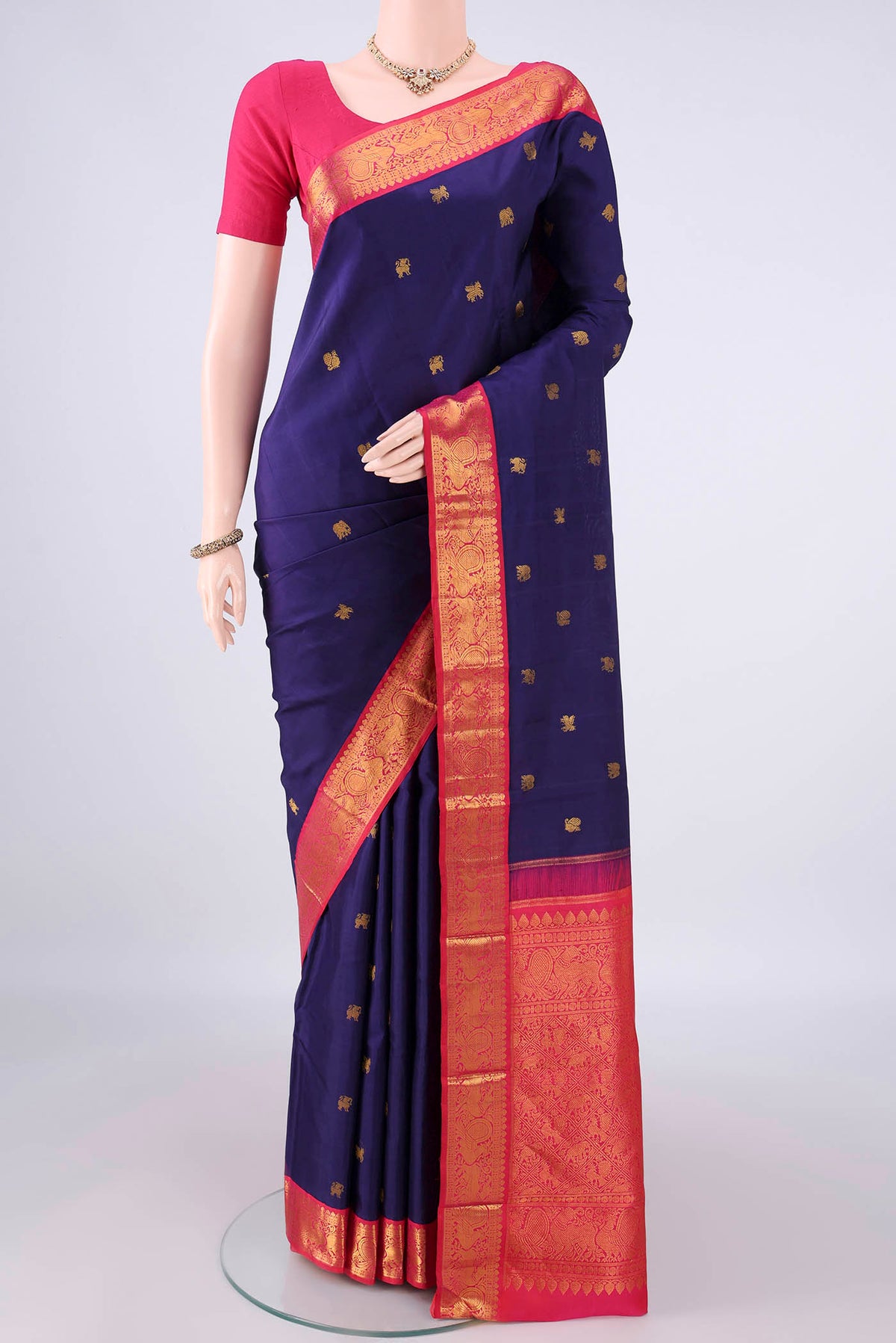Pure Silk Navy Blue Kanjivaram Saree with Zari Butta on the body and Zari Border.  displayed on a mannequin