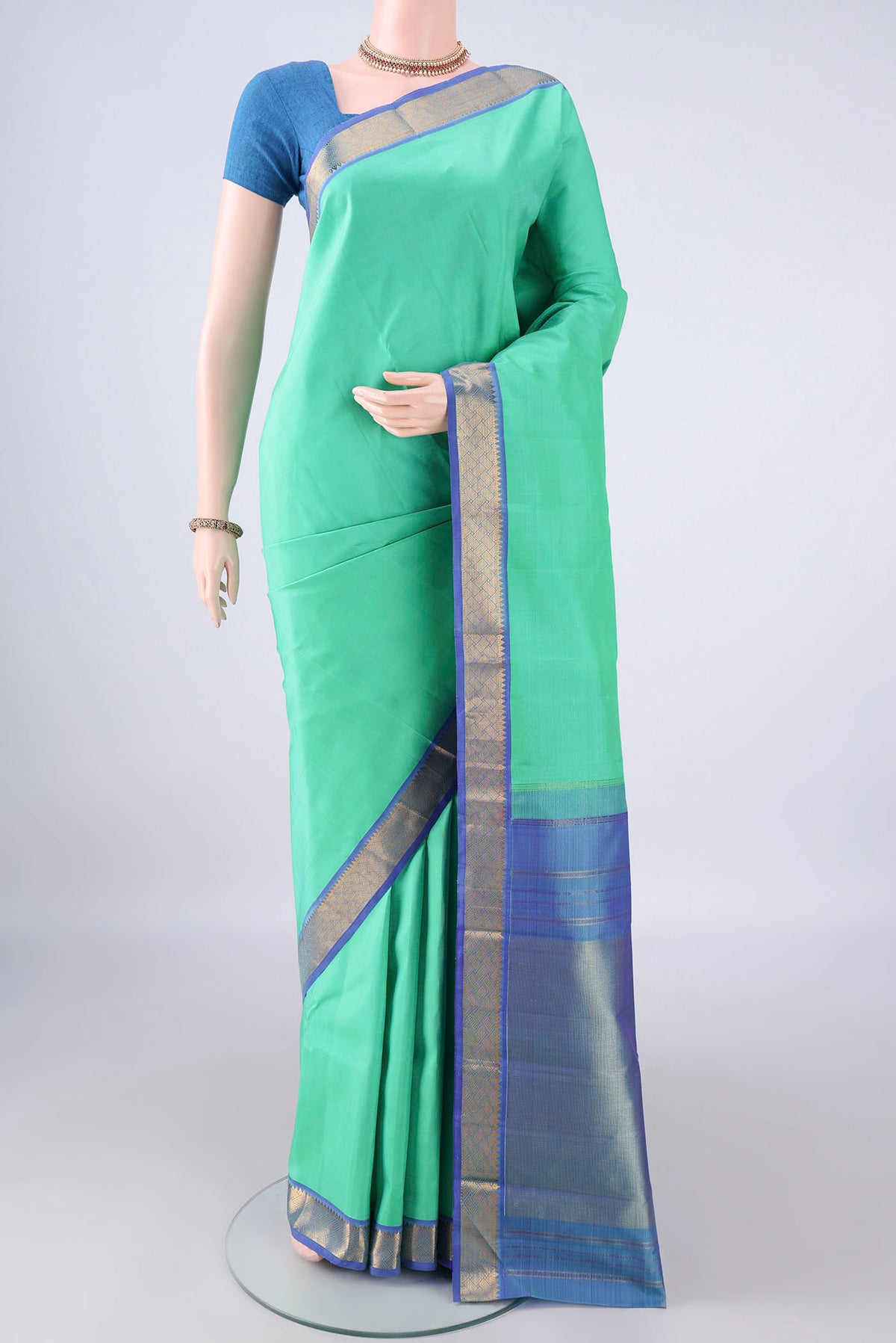 Pure Silk Sea Green Kanchipuram Saree with Plain Body and Zari Border.  displayed on a mannequin