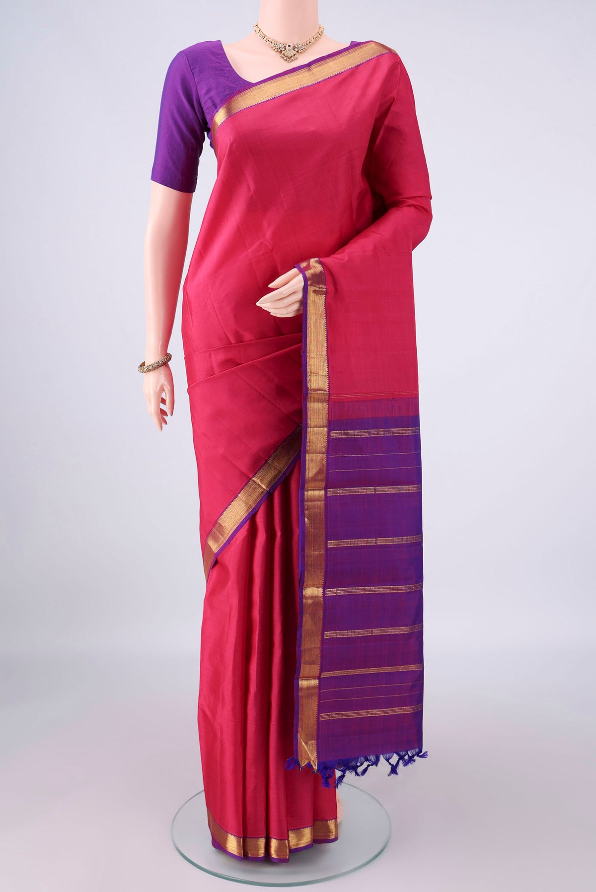 Pure Silk Coral Kanjivaram Saree with Plain Body and Zari Border.  displayed on a mannequin