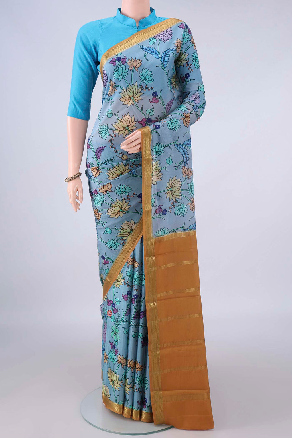 Blue Grey Mysore Crepe Saree with Printed design on the body and Zari Border.  displayed on a mannequin