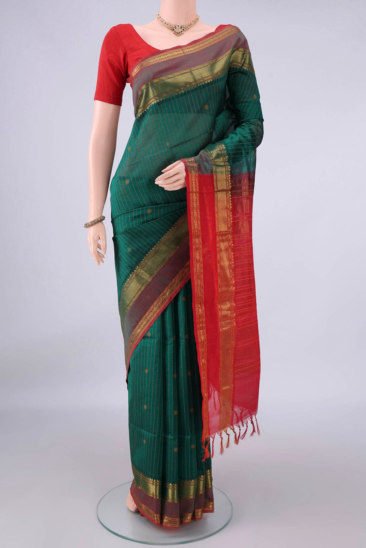 Bottle Green Coimbatore Cotton Saree with Stripes on the body and Zari Border.  displayed on a mannequin