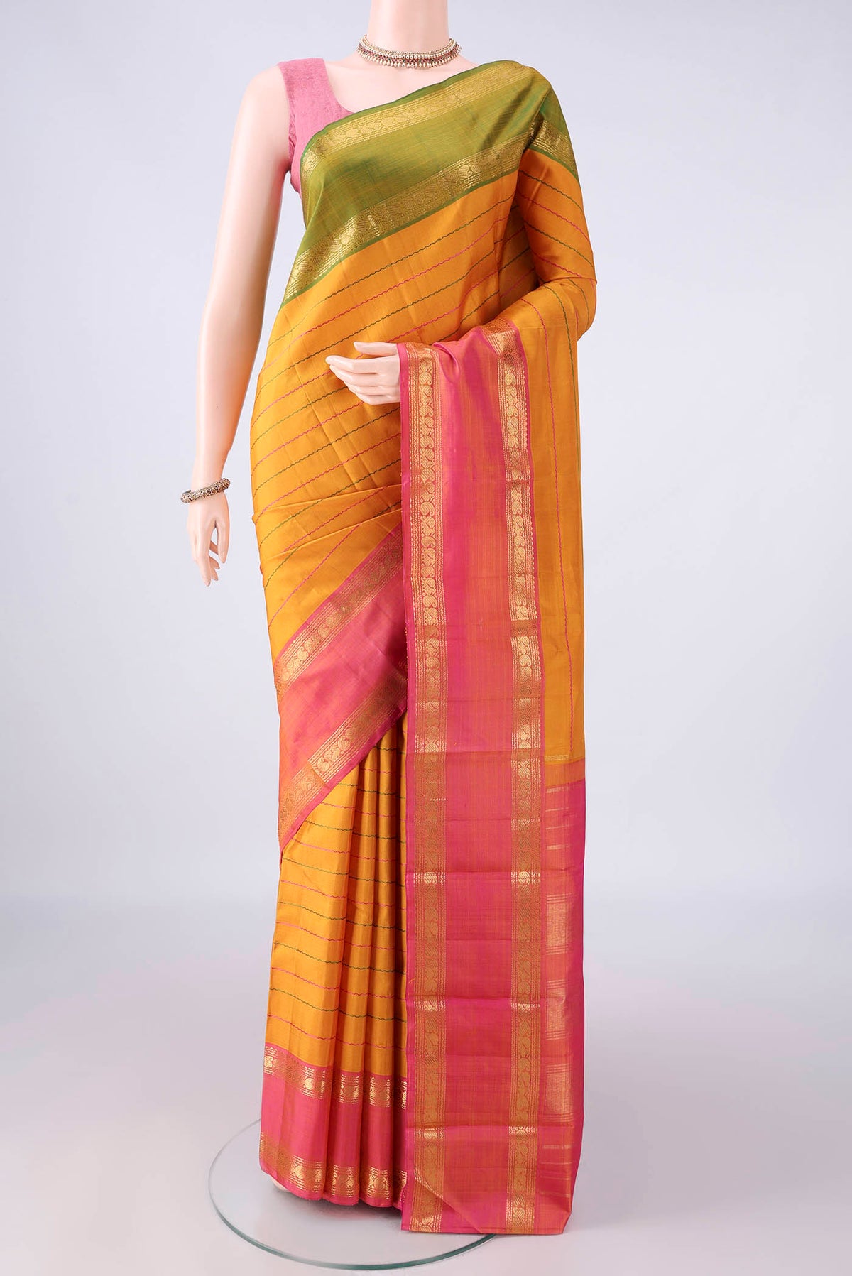 Pure Silk Mustard Kanchipuram Saree with Veldhari on the body and Ganga Jamuna Border.  displayed on a mannequin