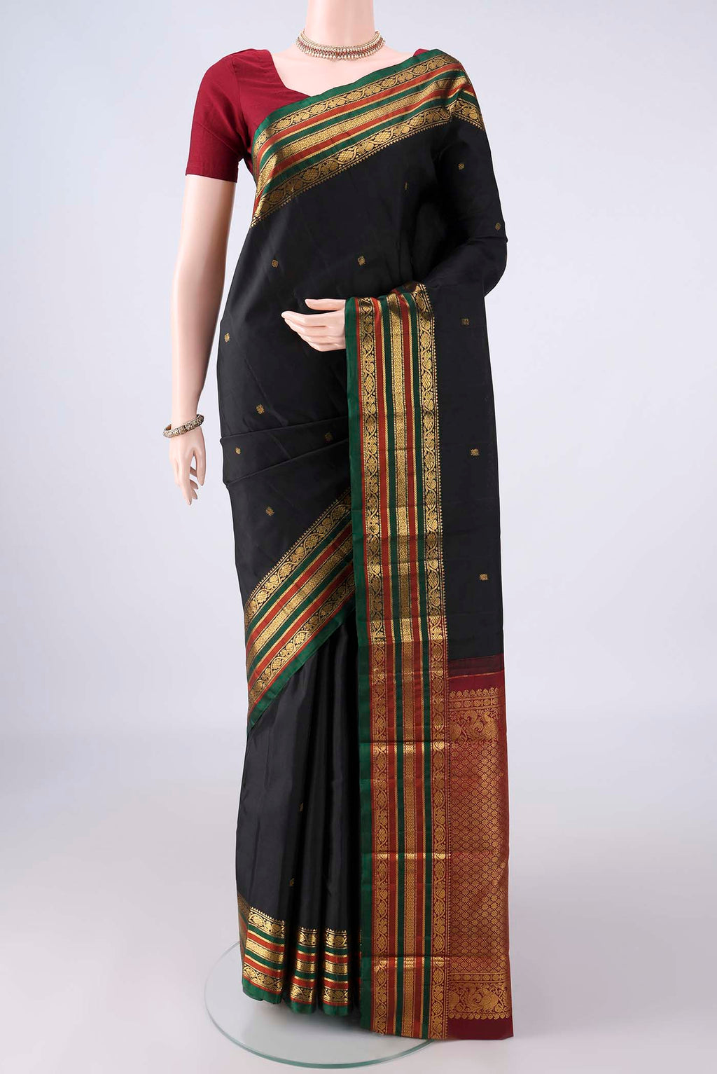 Pure Silk Black Kanjivaram Saree with Zari Butta on the body and Zari Border.  displayed on a mannequin