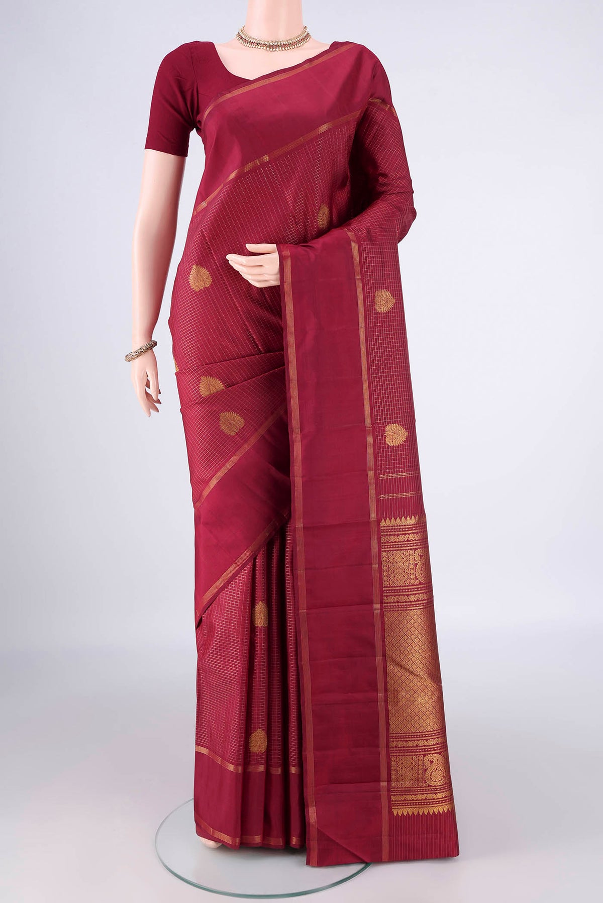 Pure Silk Maroon Kanjivaram Saree with Checked design on the body and Zari Border.  displayed on a mannequin