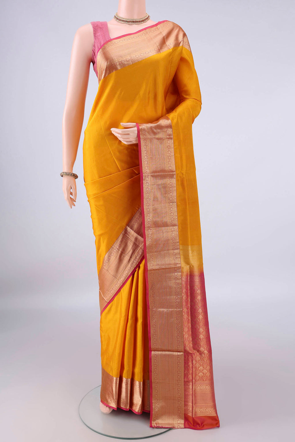 Pure Silk Mustard Soft Saree with Zari Butta on the body and Zari Border.  displayed on a mannequin
