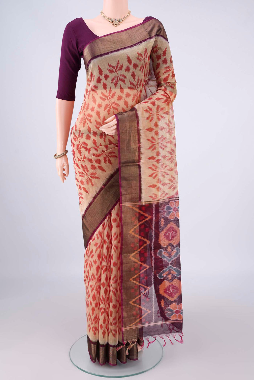 Beige Silk Cotton Saree with Ikat design on the body and Zari Border.  displayed on a mannequin