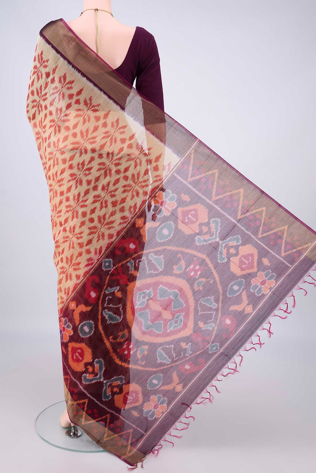 Flat view of Beige Silk Cotton Saree with Ikat design on the body and Zari Border. 