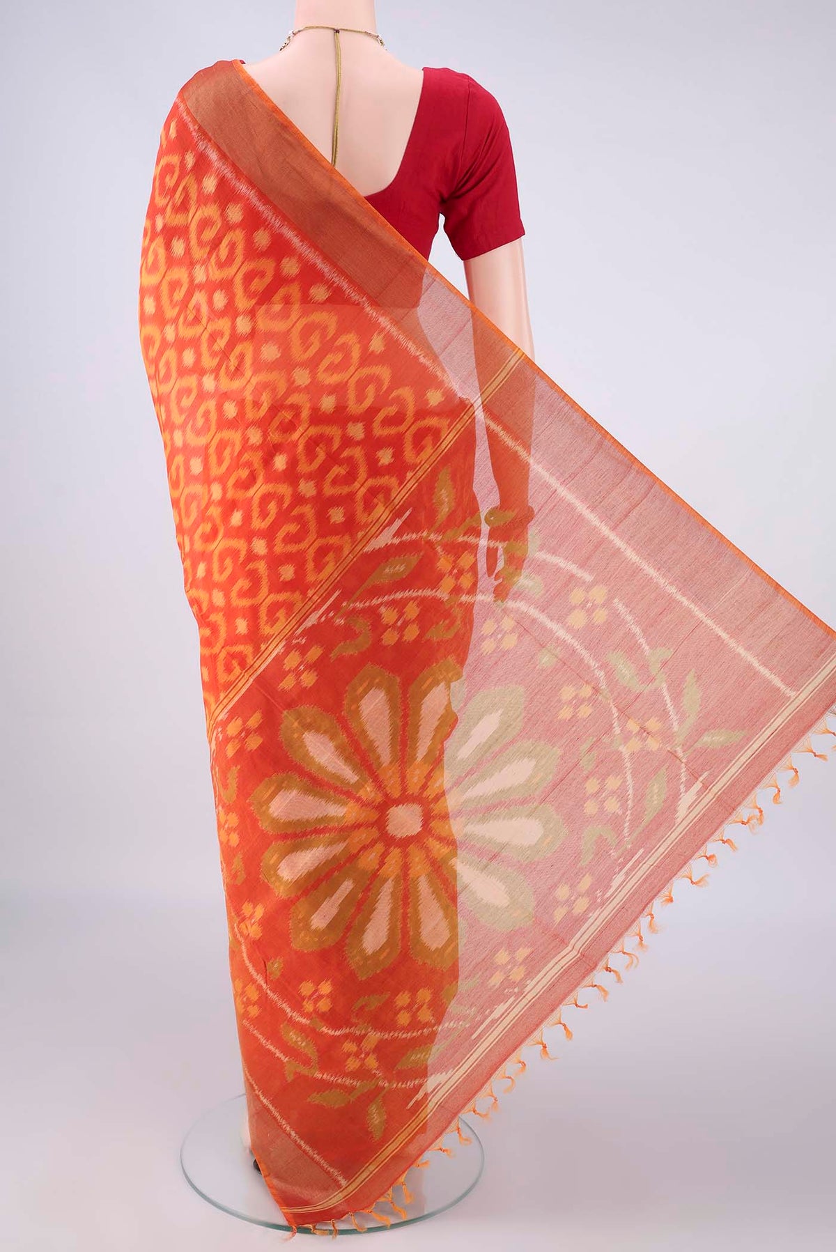 Flat view of Brick Orange Silk Cotton Saree with Ikat design on the body and Zari Border. 
