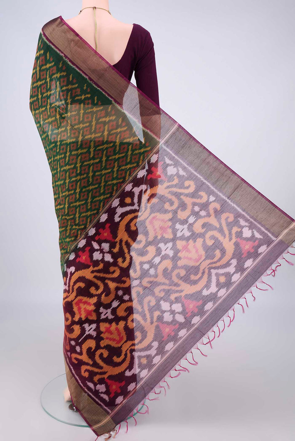 Flat view of Bottle Green Silk Cotton Saree with Ikat design on the body and Zari Border. 