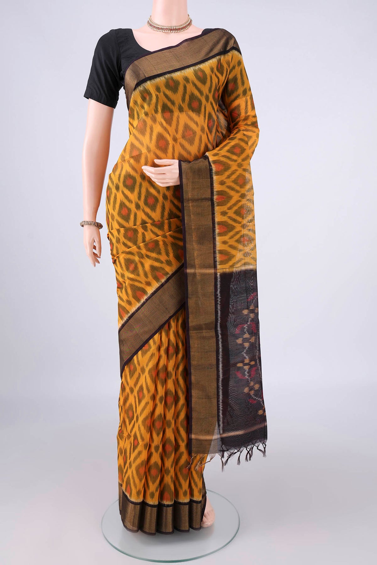 Yellow Silk Cotton Saree with Ikat design on the body and Zari Border.  displayed on a mannequin