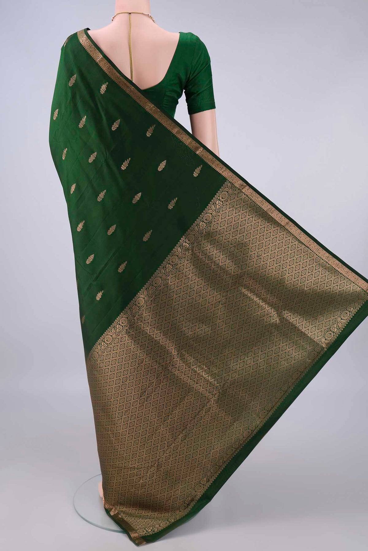 Flat view of Pure Silk Bottle Green Kanjivaram Saree with Zari Butta on the body and Zari Border. 