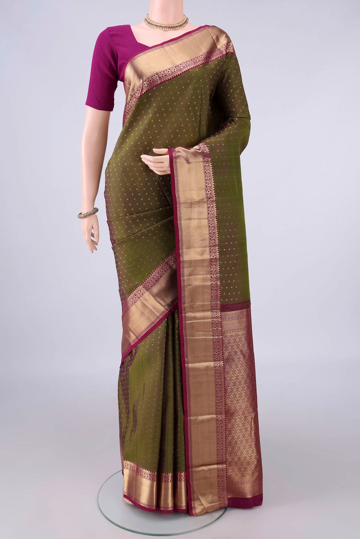 Pure Silk Mehandi Green Kanchipuram Saree with Zari Butta on the body and Zari Border.  displayed on a mannequin