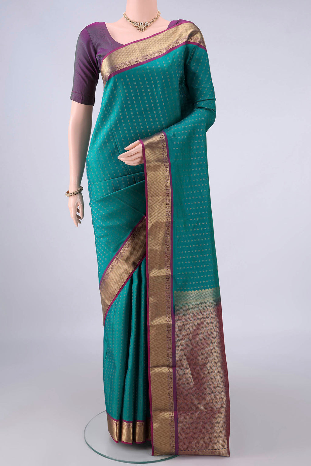 Pure Silk Sea Green Kanchipuram Saree with Zari Butta on the body and Zari Border.  displayed on a mannequin