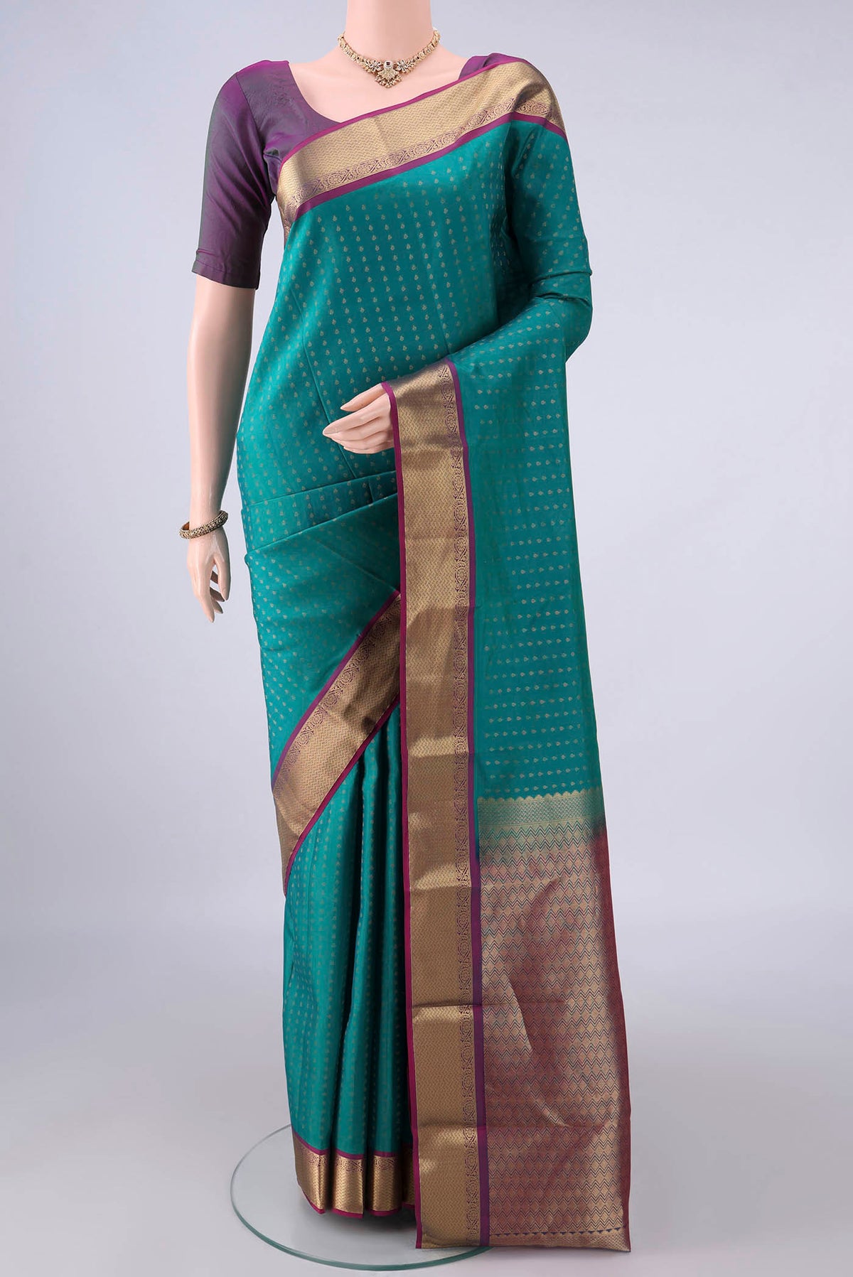 Pure Silk Sea Green Kanchipuram Saree with Zari Butta on the body and Zari Border.  displayed on a mannequin