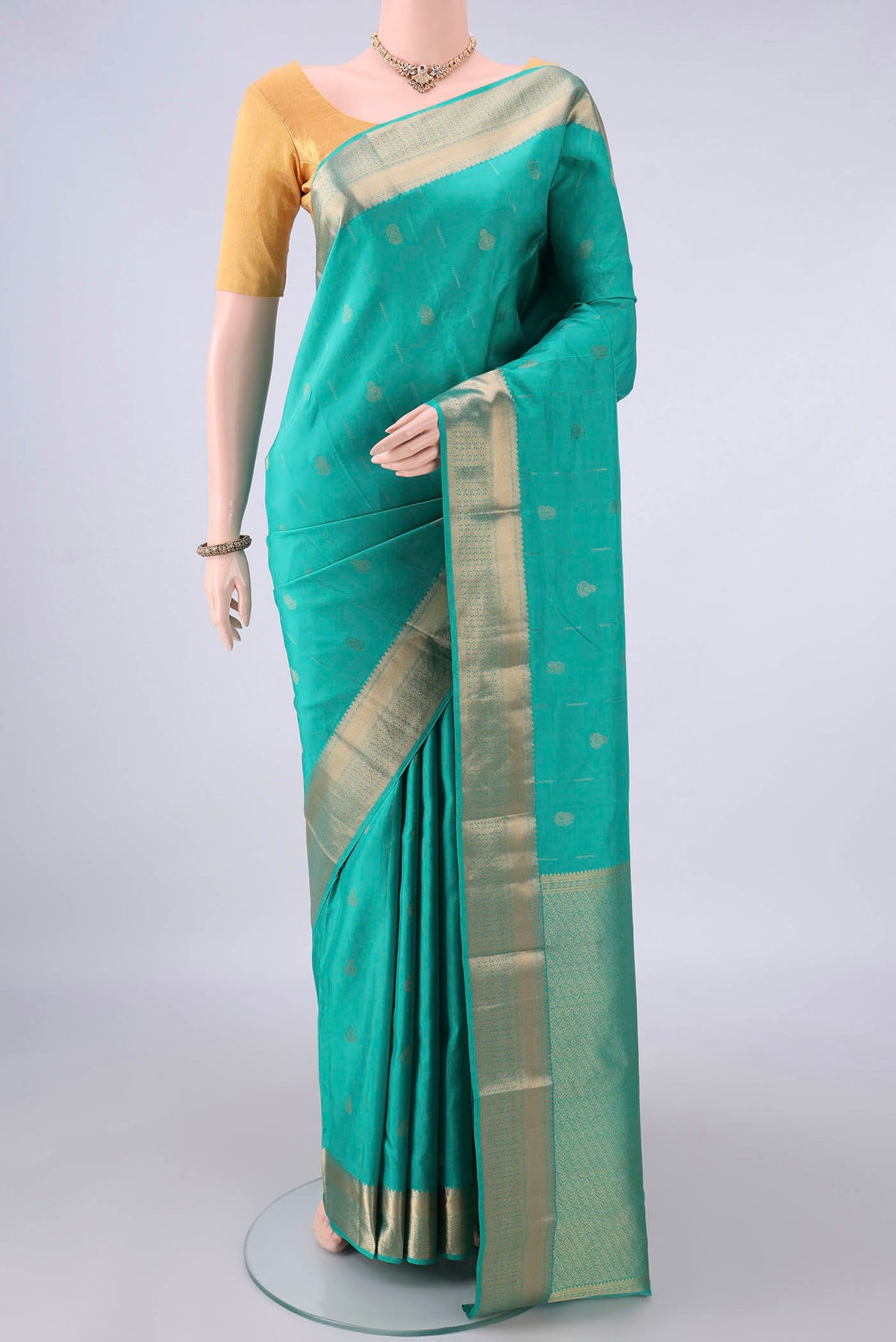 Pure Silk Sea Green Kanchipuram Saree with Zari Butta on the body and Zari Border.  displayed on a mannequin