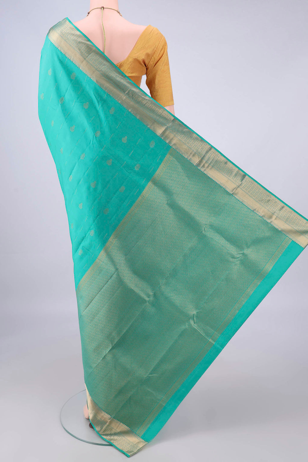 Flat view of Pure Silk Sea Green Kanchipuram Saree with Zari Butta on the body and Zari Border. 