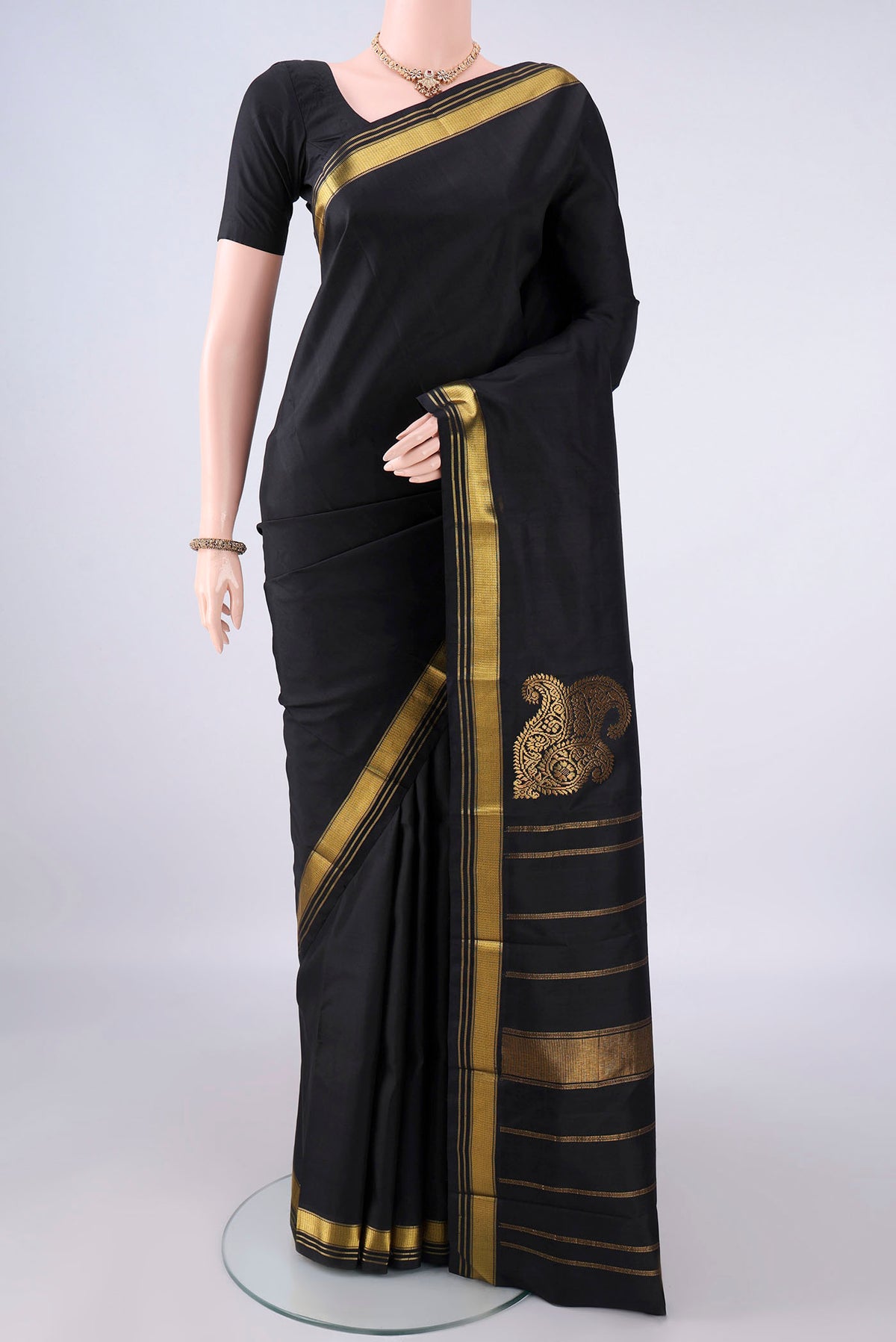 Pure Silk Black Kanchipuram Saree with Plain Body and Zari Border.  displayed on a mannequin