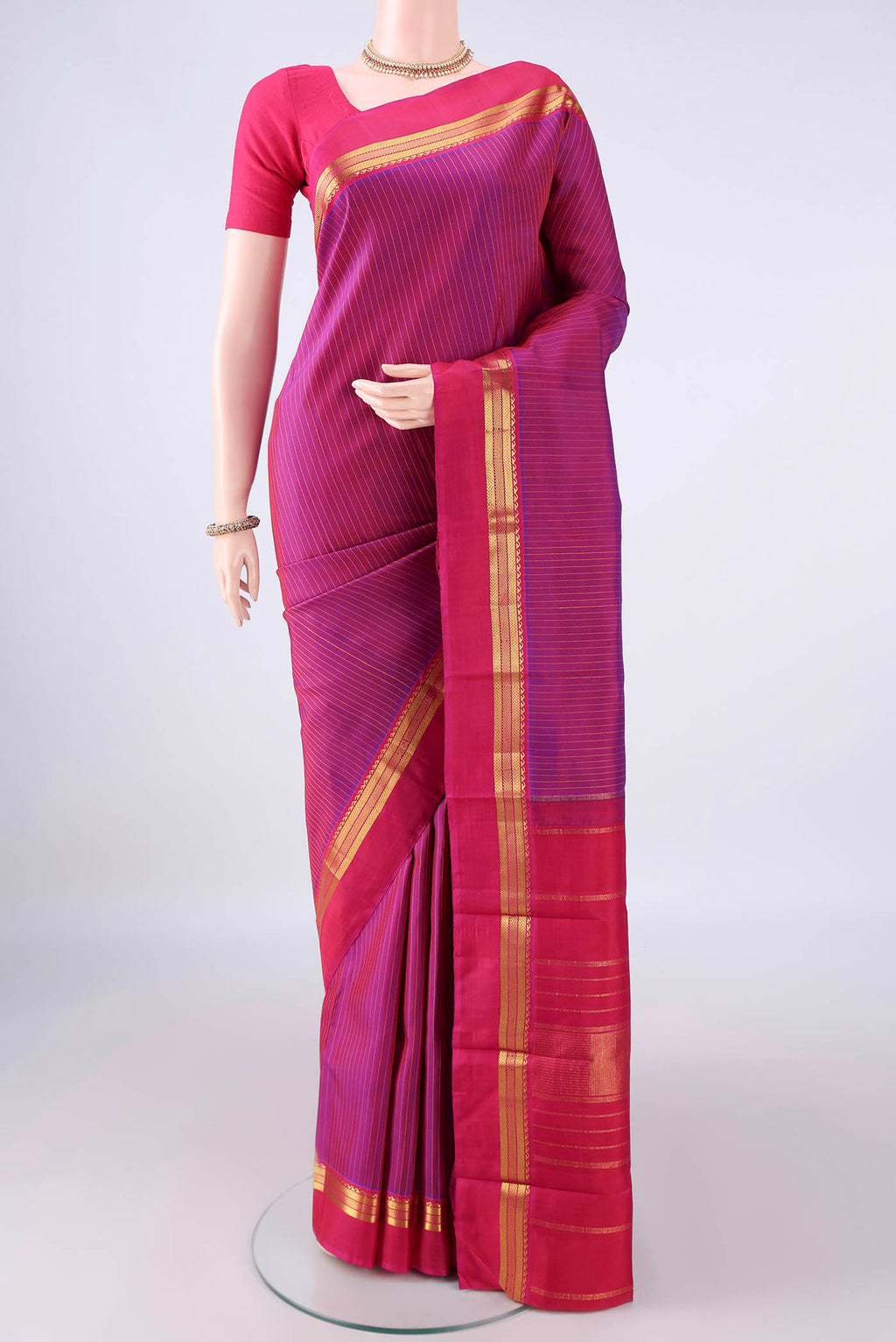 Pure Silk Magenta Kanchipuram Saree with Stripes on the body and Zari Border.  displayed on a mannequin