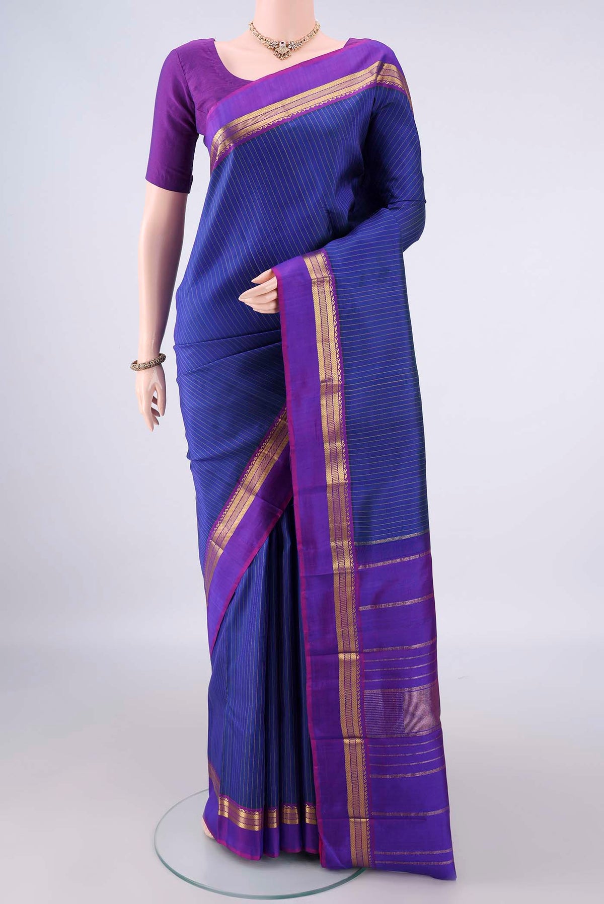 Pure Silk Blue Kanchipuram Saree with Stripes on the body and Zari Border.  displayed on a mannequin