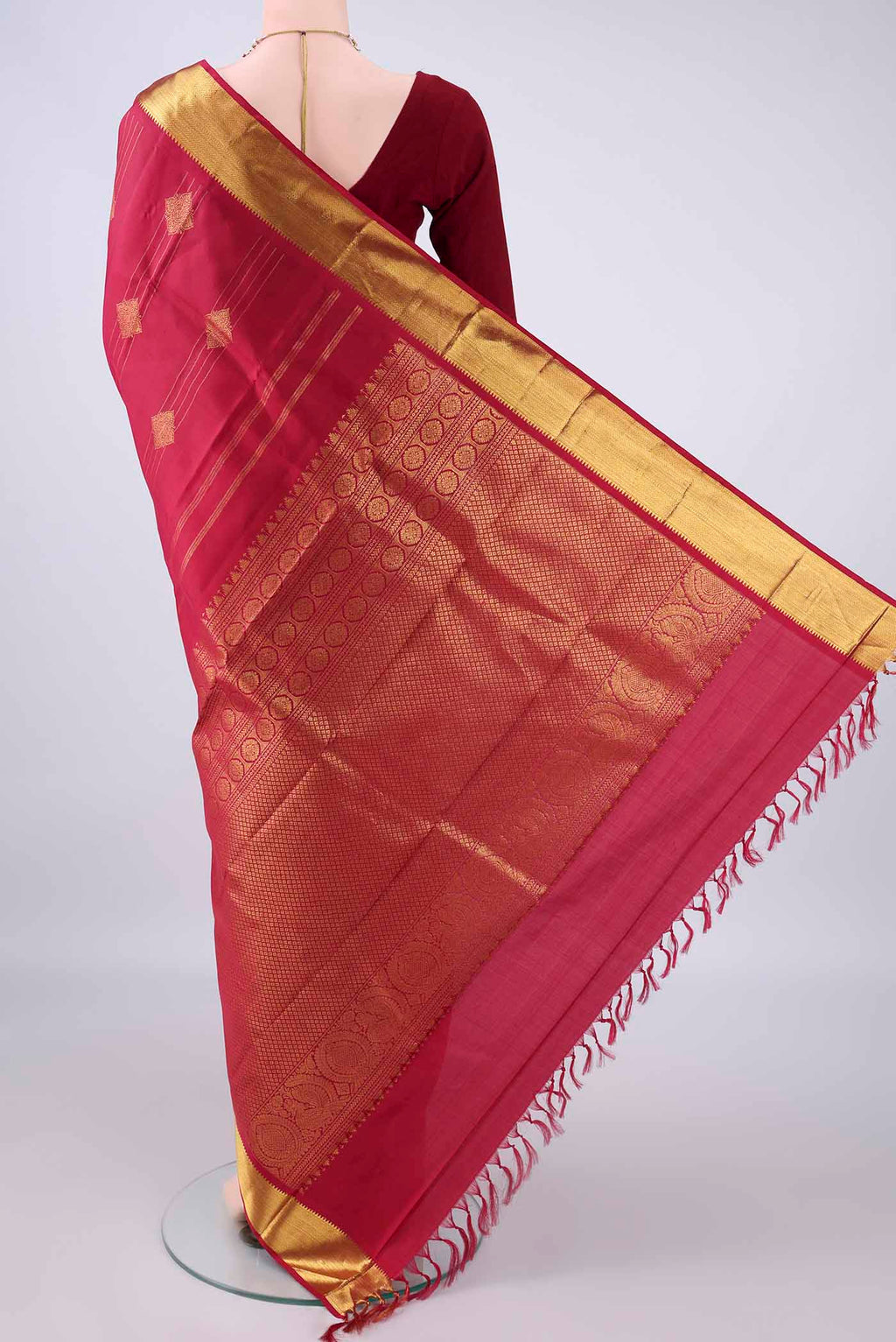 Flat view of Pure Silk Maroon Kanjivaram Saree with Zari Butta on the body and Zari Border. 
