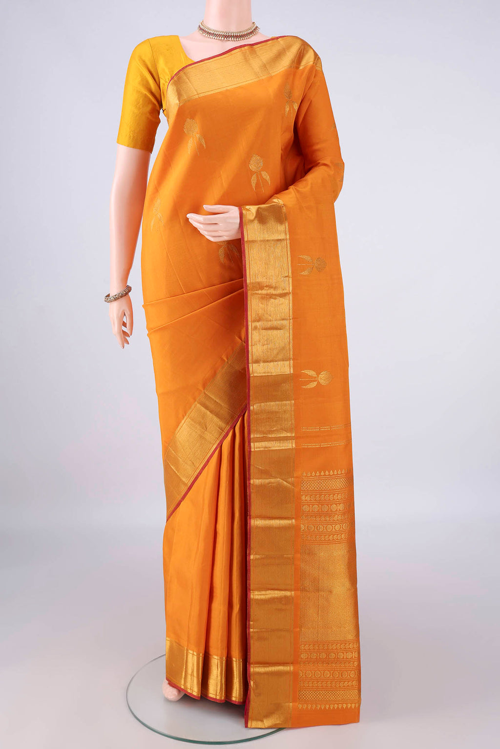 Pure Silk Mustard Kanjivaram Saree with Zari Butta on the body and Zari Border.  displayed on a mannequin