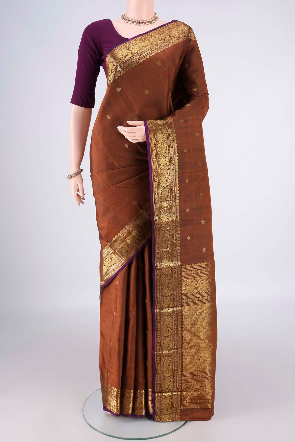 Pure Silk Bronze Kanjivaram Saree with Zari Butta on the body and Zari Border.  displayed on a mannequin